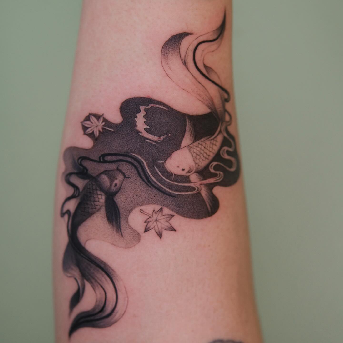 Koi fish and flowers black and grey tattoo on the forearm by Toki
