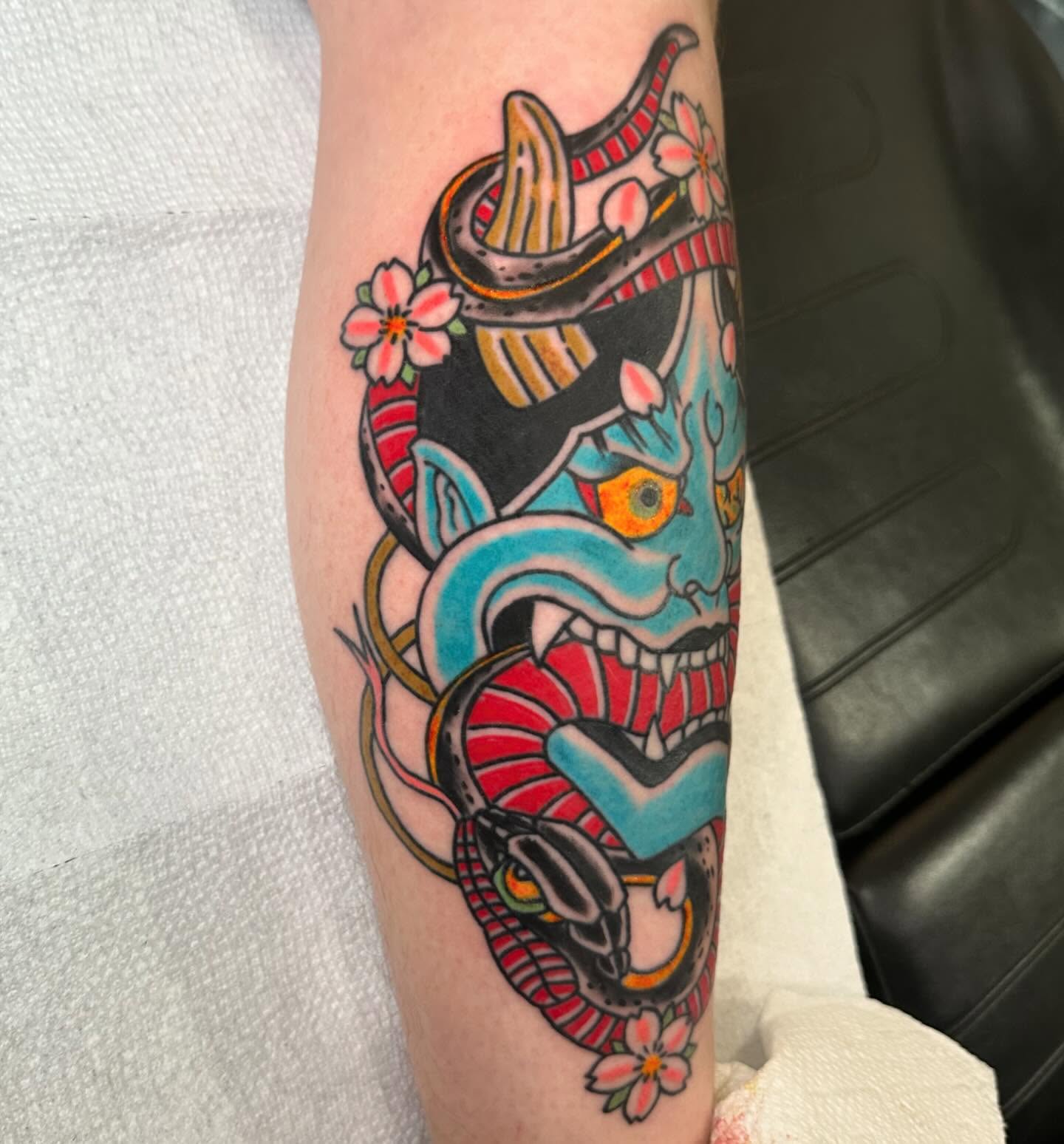 Mask with snake American traditional tattoo on the forearm by 𝕯𝖗𝖊𝖜 𝕲𝖎𝖑𝖊𝖘 𝕵𝖆𝖙𝖙𝖔𝖔, Addison, Texas