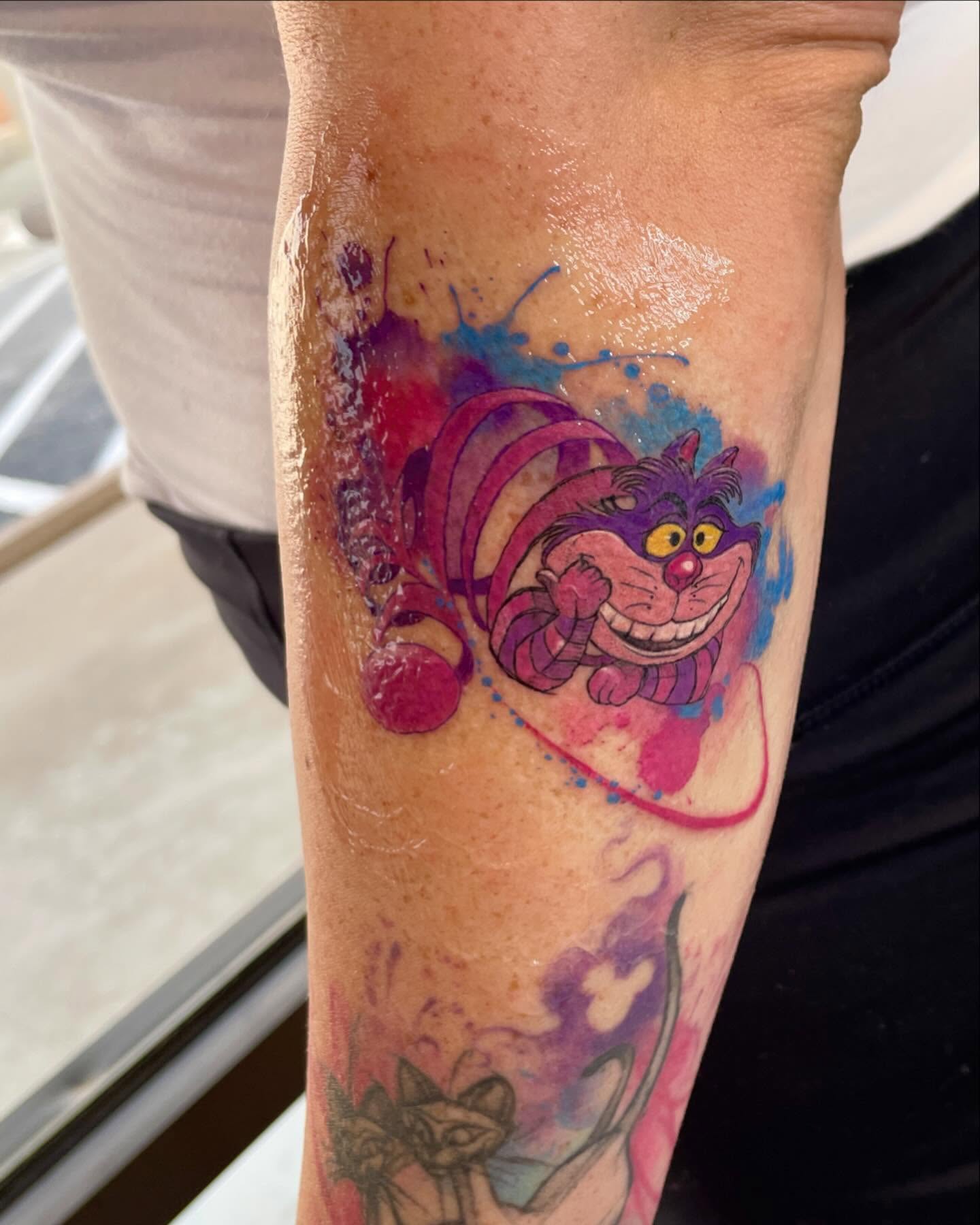 Cheshire cat watercolor tattoo on the forearm by Melissa Rose Moya