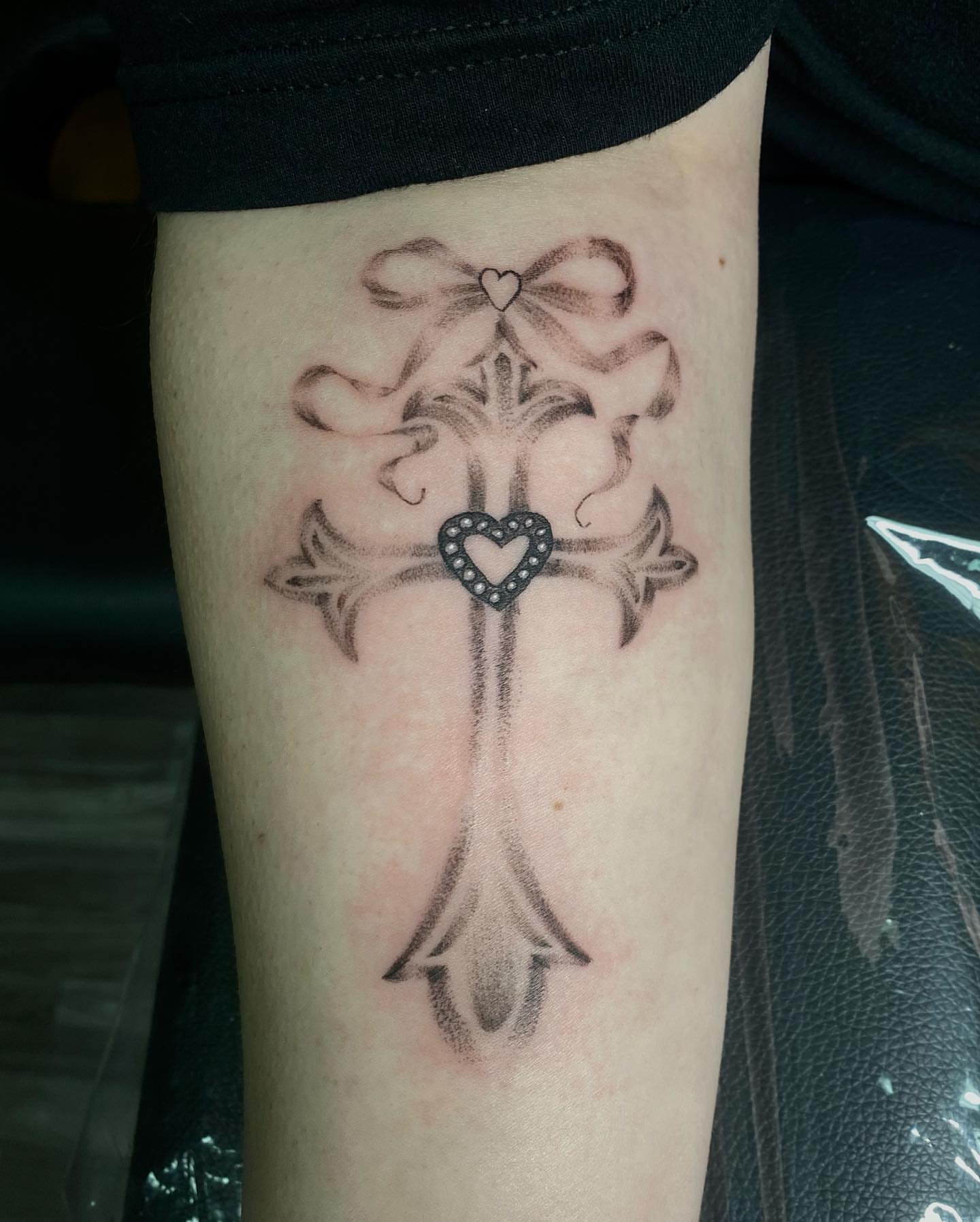 Cross with heart black and grey tattoo on the forearm by 𝙰𝚛𝚕𝚒𝚗𝚐𝚝𝚘𝚗 𝚃𝚊𝚝𝚝𝚘𝚘 𝙰𝚛𝚝𝚒𝚜𝚝 ✴︎ 𝚝𝚊𝚝𝚜𝚇𝚟𝚊𝚕