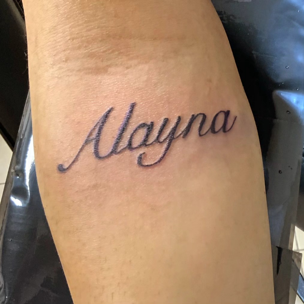 Alayna lettering script tattoo on the forearm by Lopez Dautruche