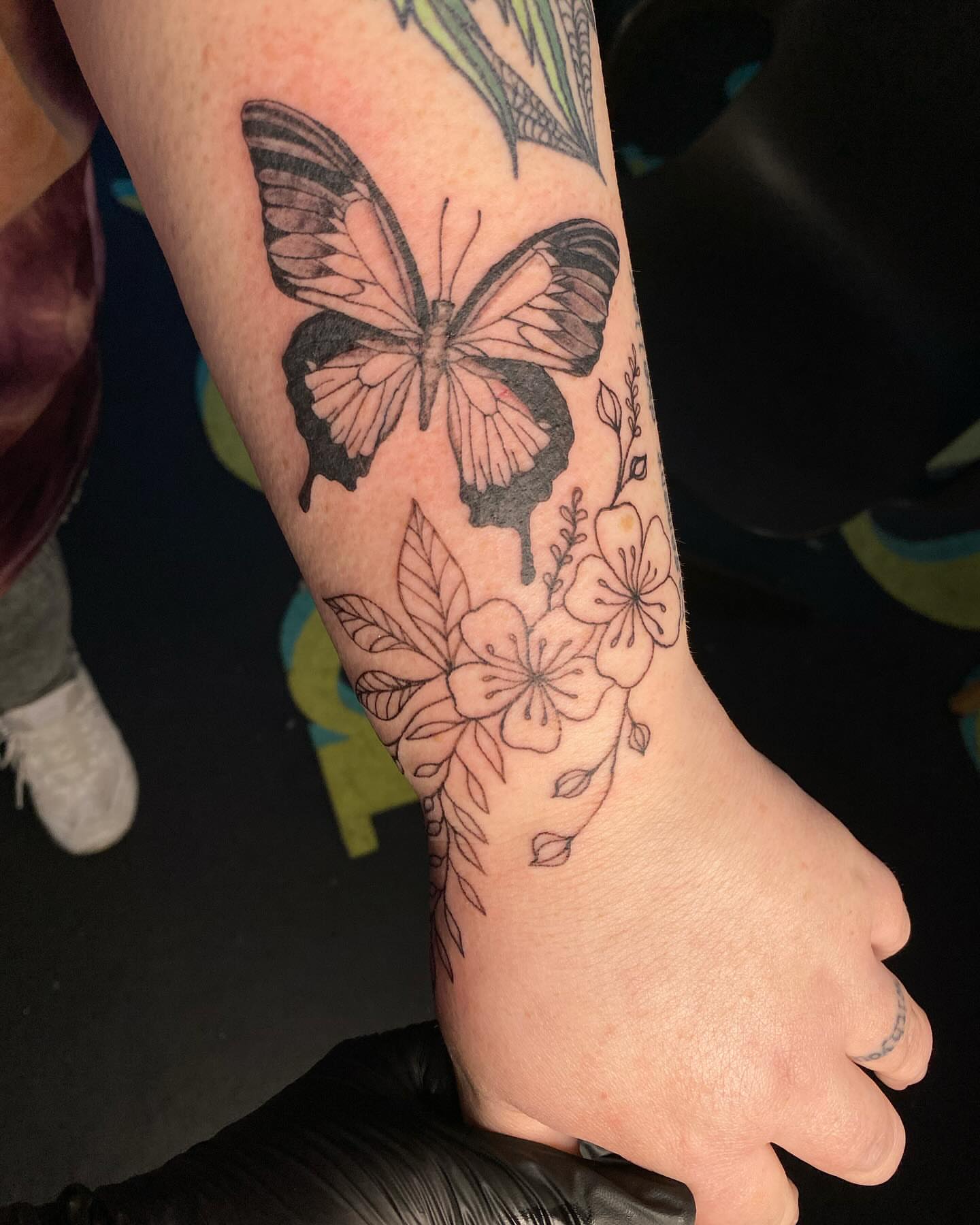 Butterfly and flowers black and grey tattoo on the foot by Tesla Kohl