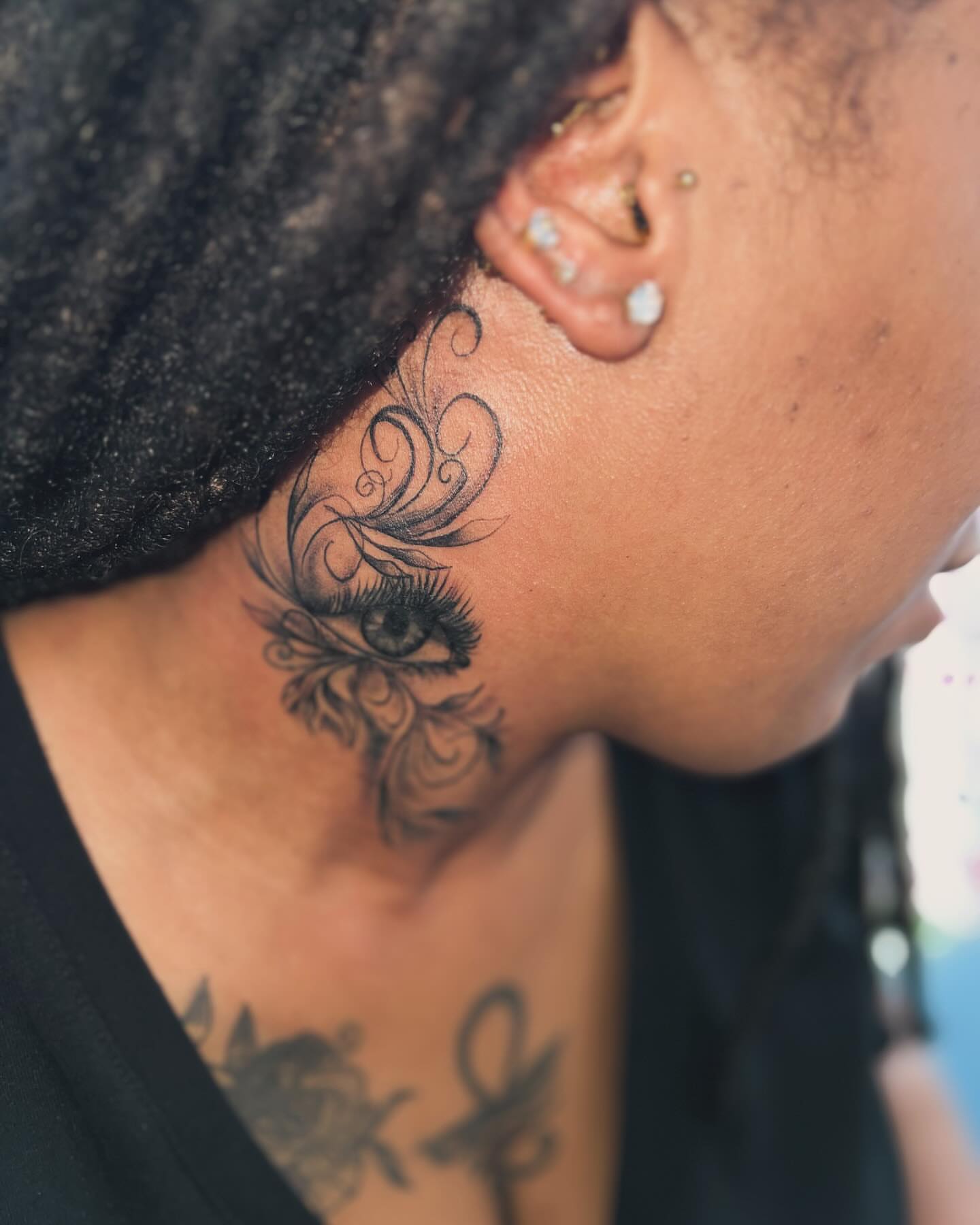 Eye with floral swirls black and grey tattoo on the neck by oxideTattoo, Morne-à-l'Eau