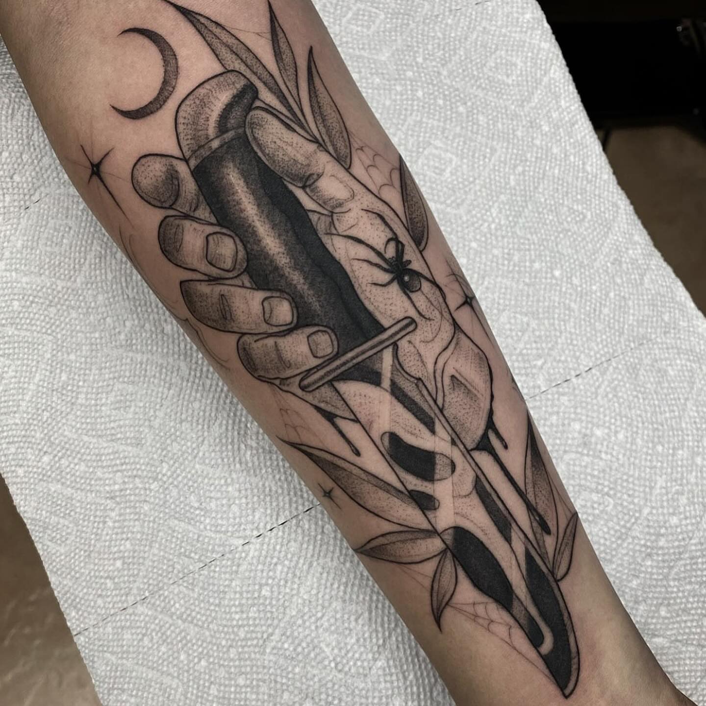 Hand holding knife dotwork tattoo on the forearm by Marissa Tattoos