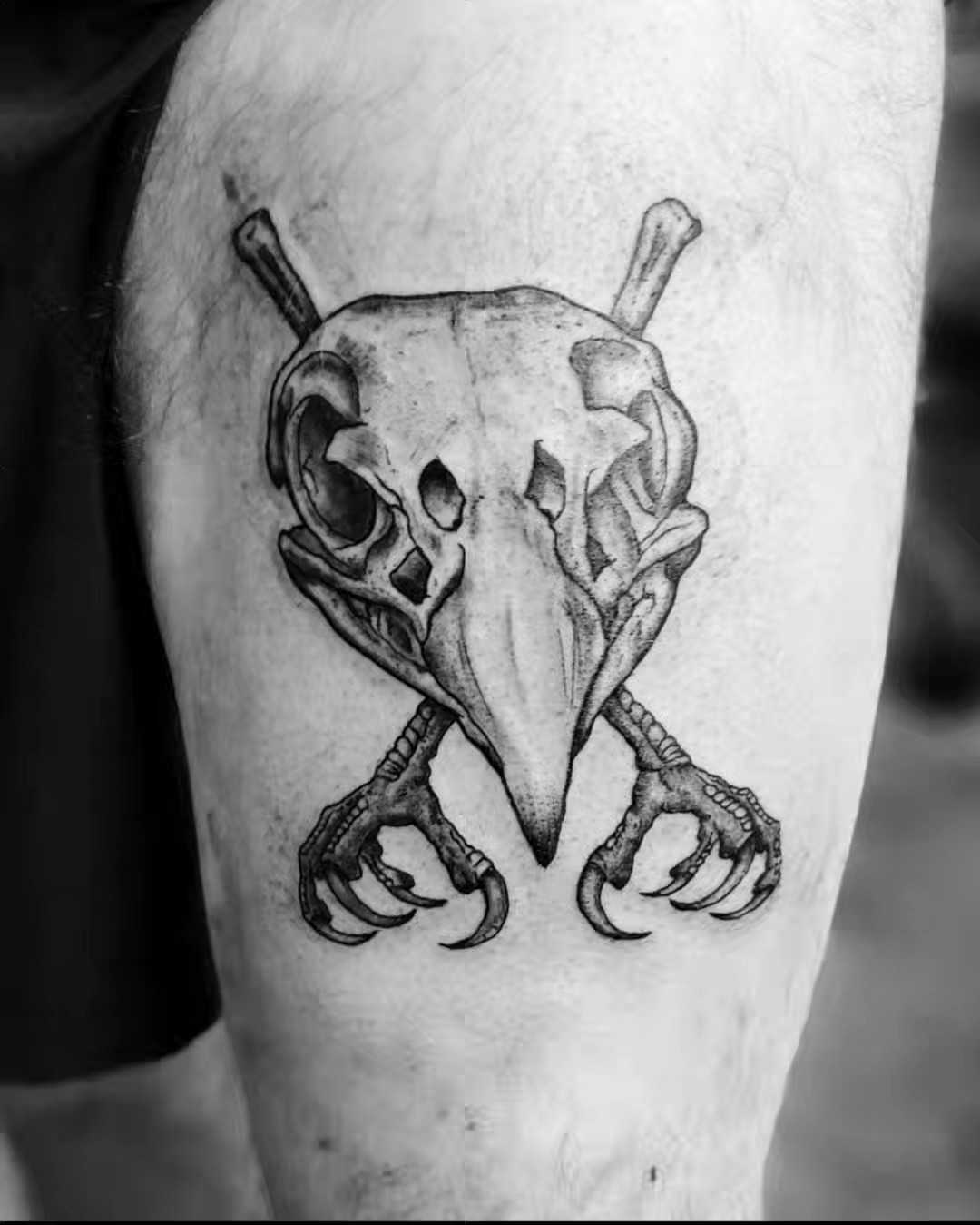 Skull and bones black and grey tattoo on the thigh by Tim Andrews