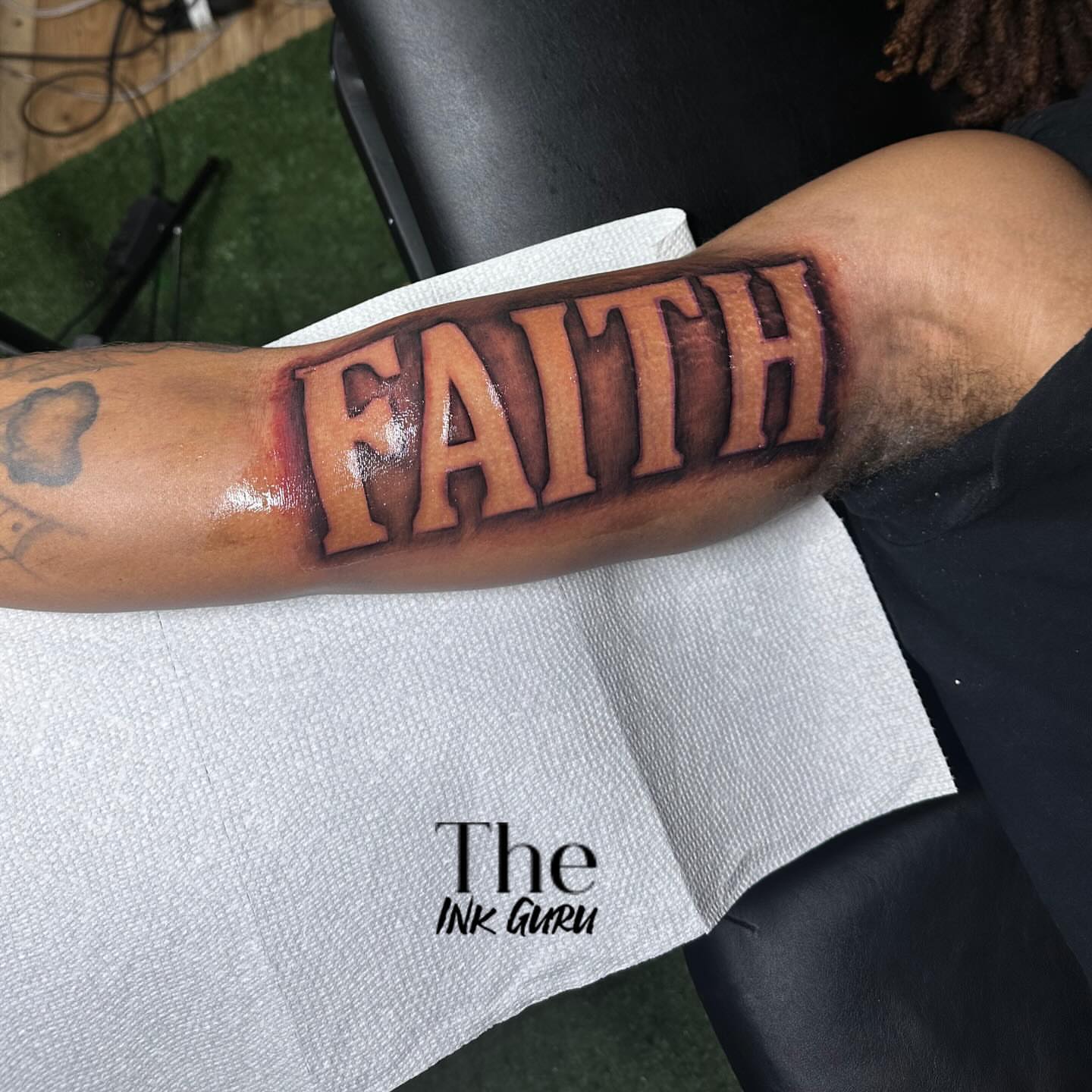 FAITH lettering script tattoo on the forearm by The Ink Guru.