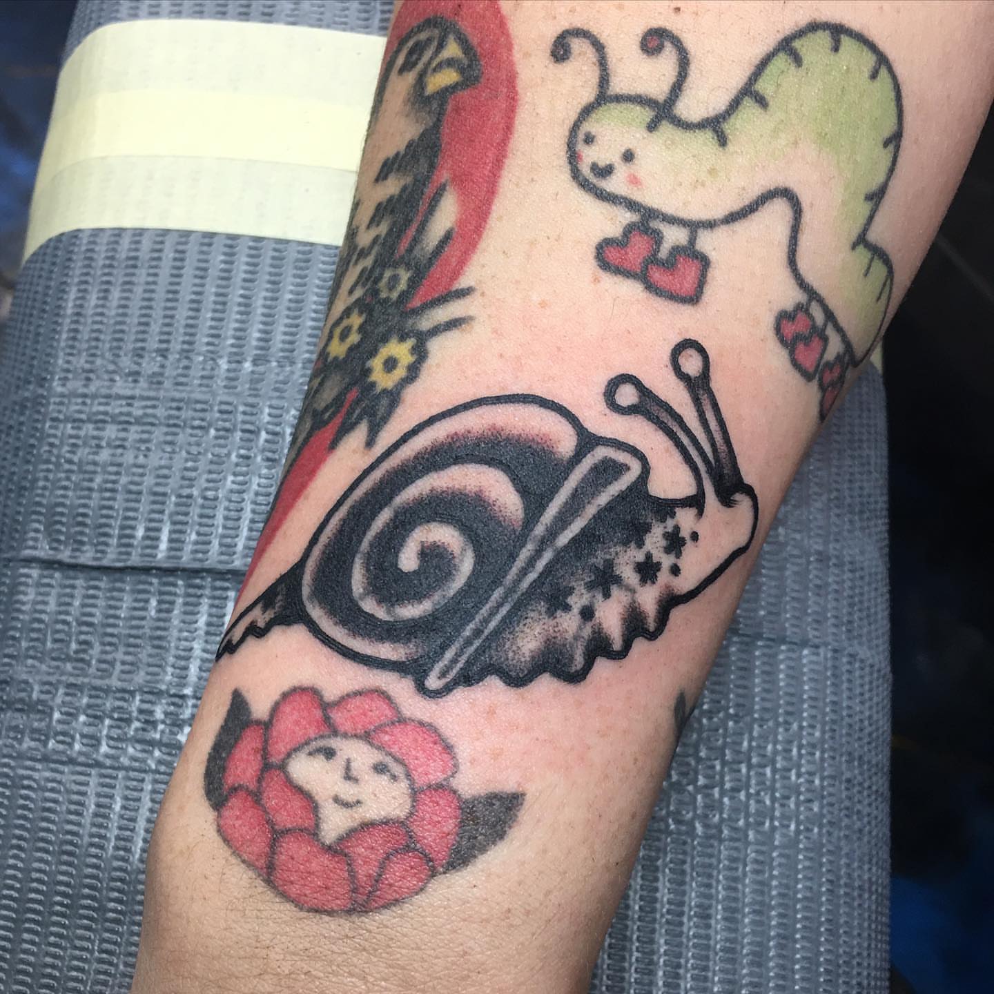 Snail and flower American traditional tattoo on the forearm by Abbey Martin, Nashville, Tennessee