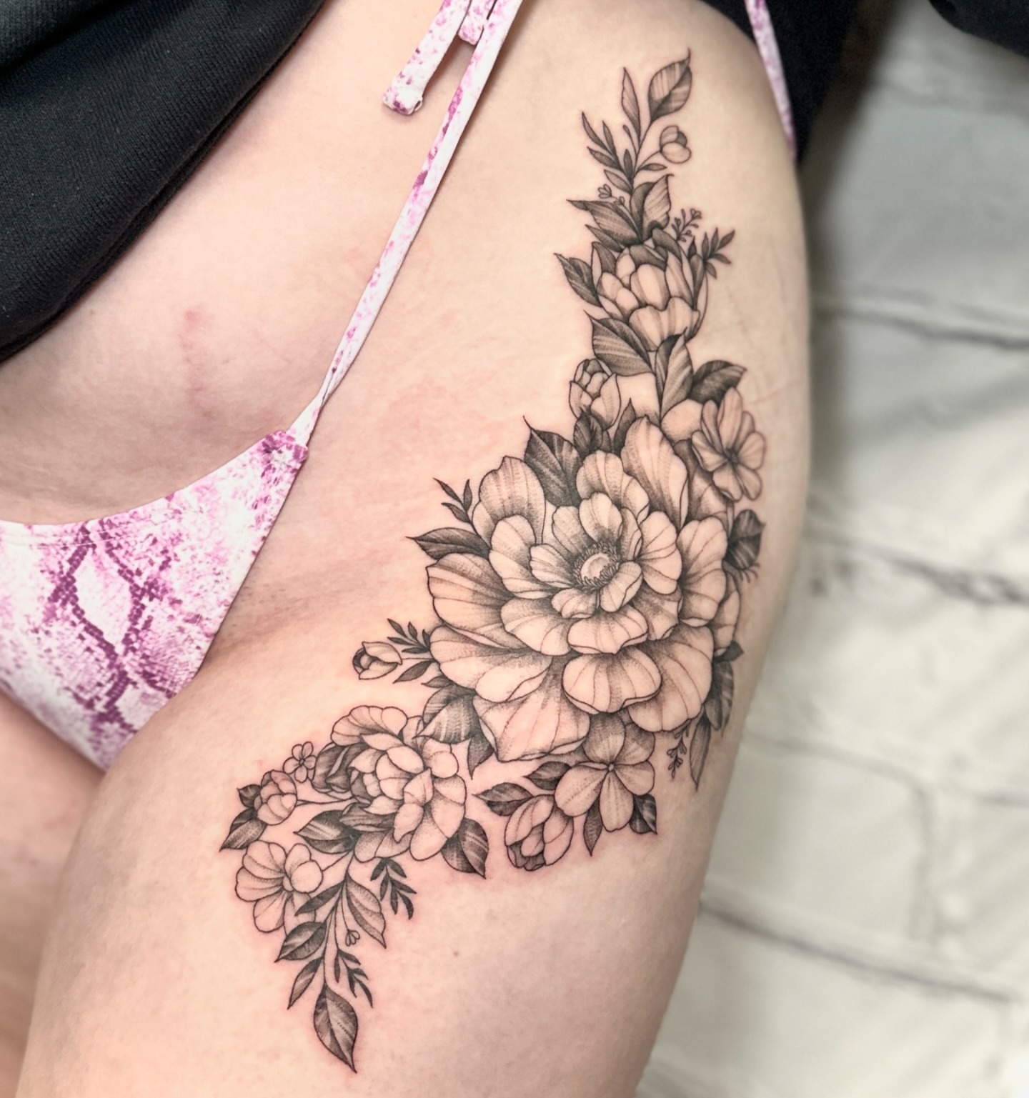Floral bouquet black and grey tattoo on the thigh by Stephen Hansen