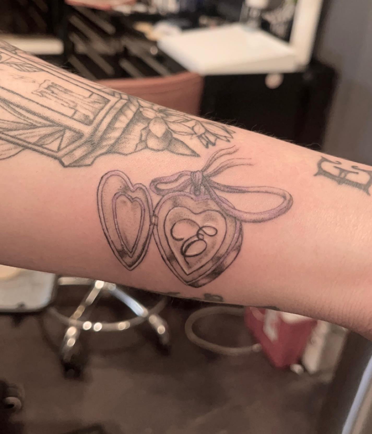 Heart locket black and grey tattoo on the forearm by Kenzie🖤