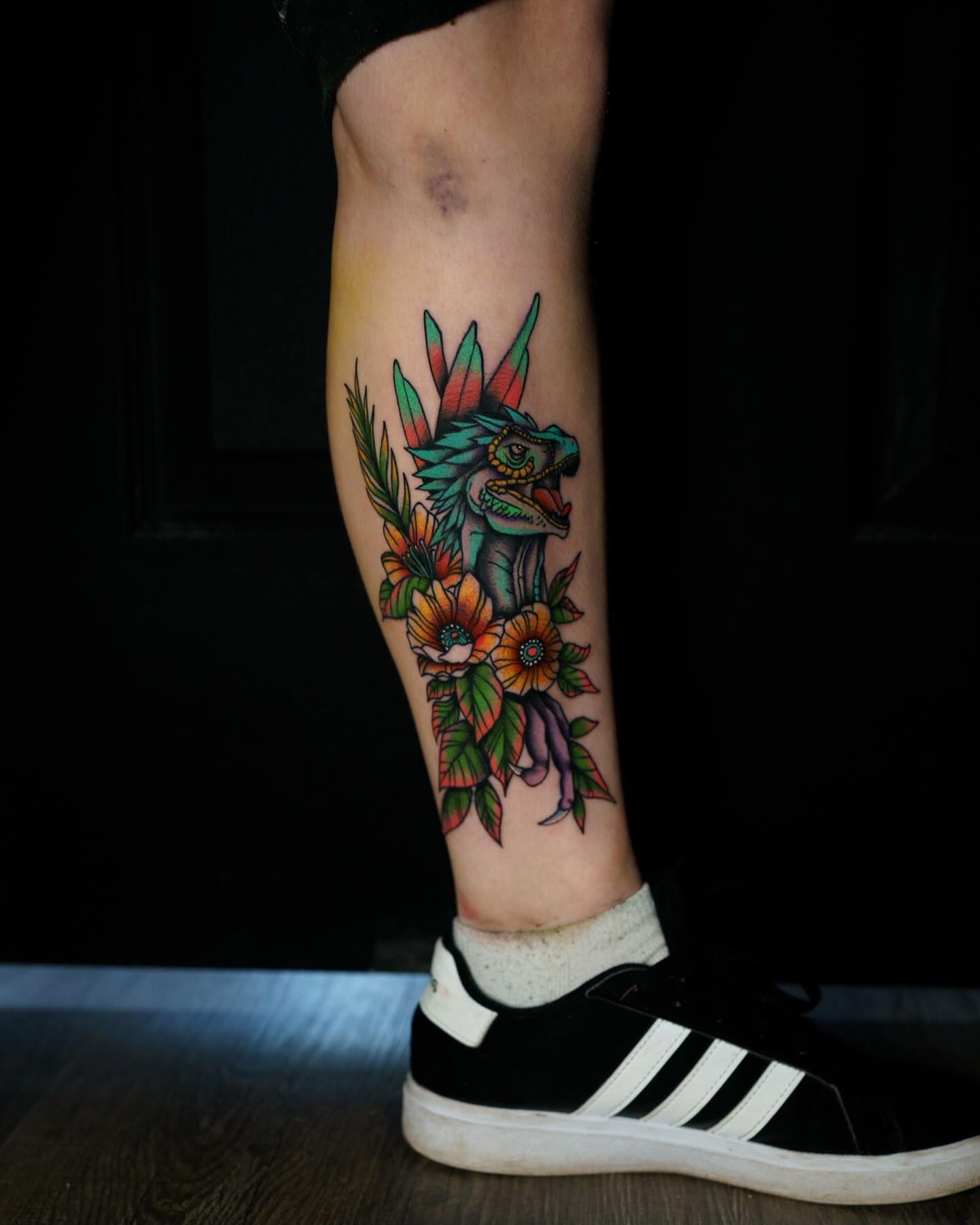Dragon and flowers American traditional tattoo on the calf by Nate Masi
