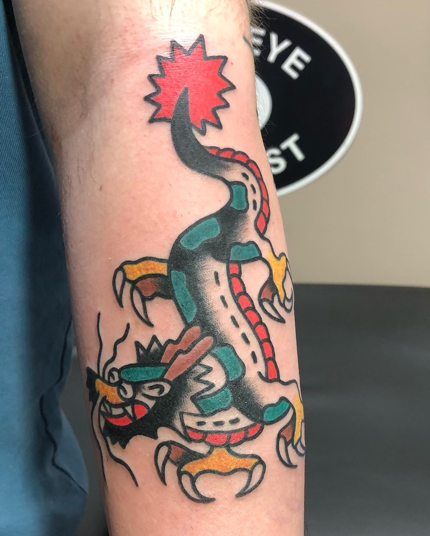 Dinosaur American traditional tattoo on the forearm by Brent G