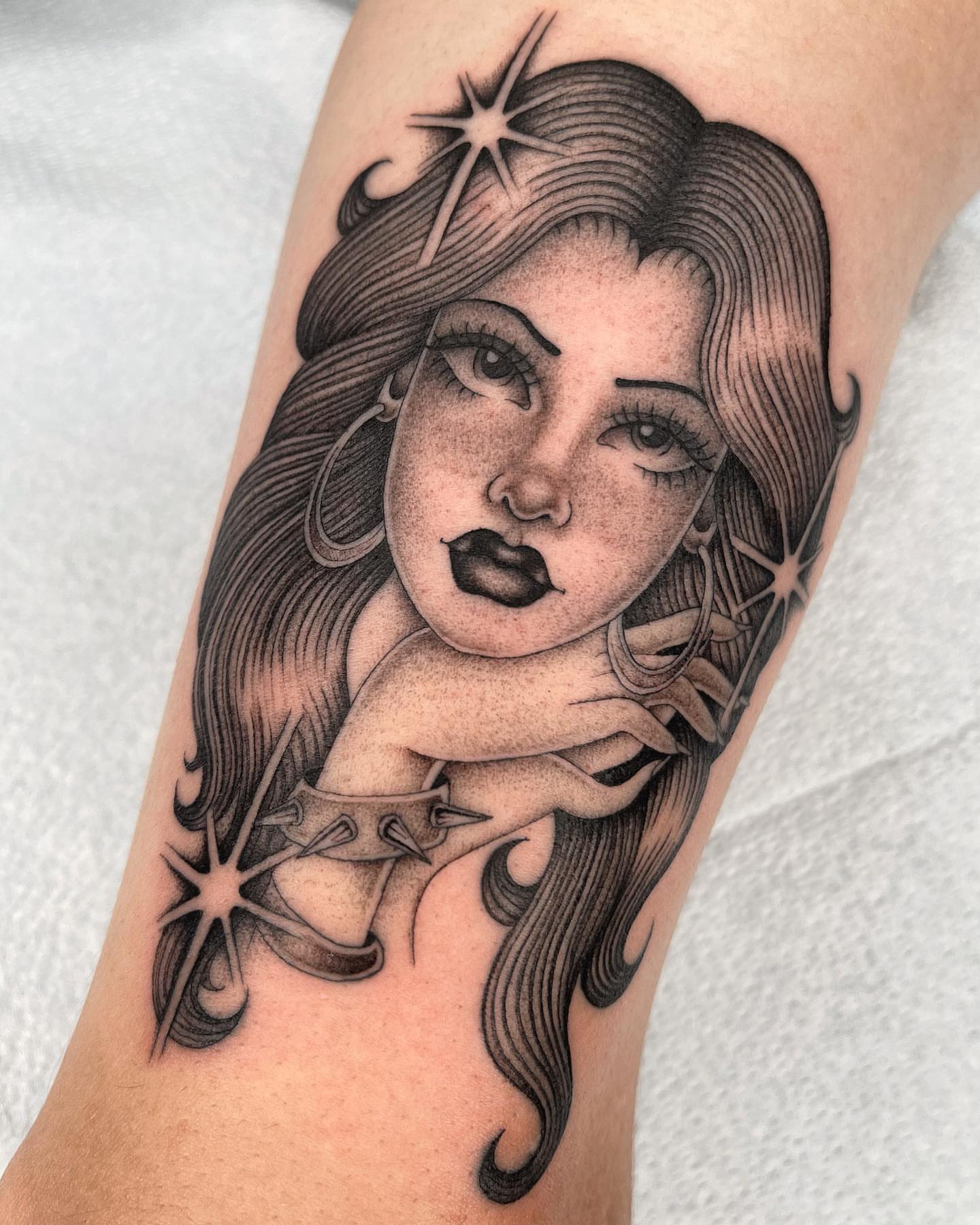 Woman with stars realism tattoo on the forearm by Tiyanna Garlic