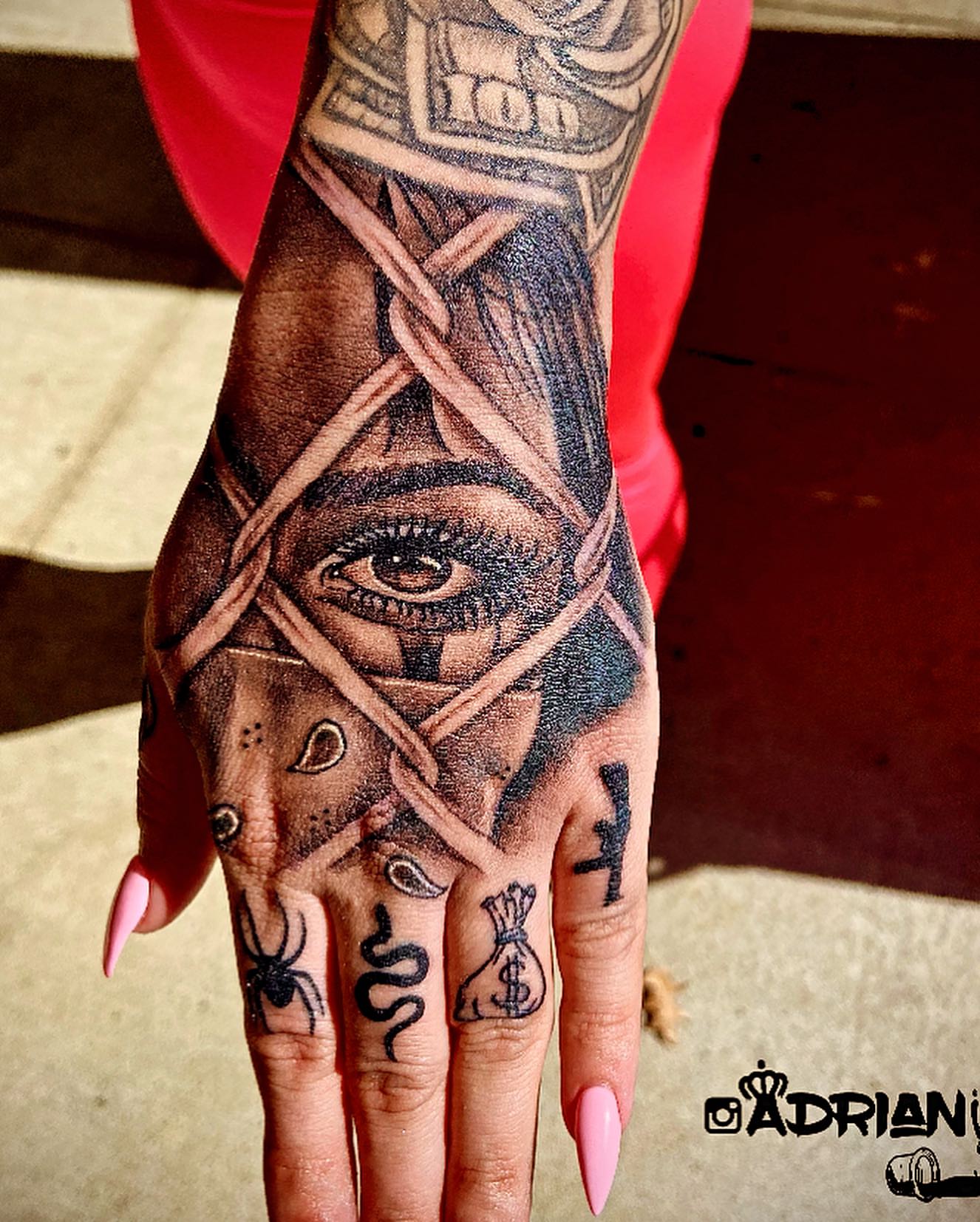 Eye and bandages geometric tattoo on the hand by Adrian Shan Carr