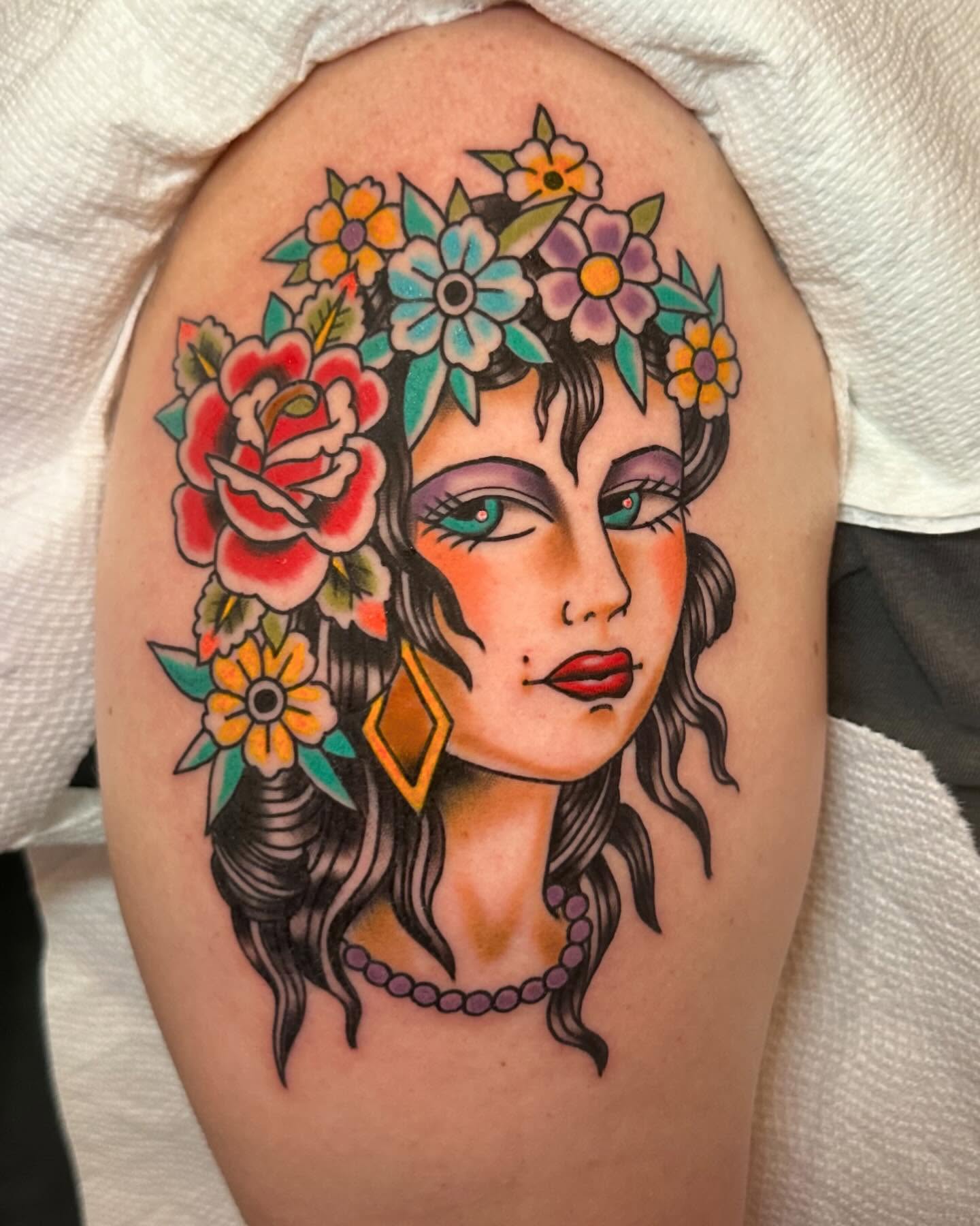 Woman with floral crown American traditional tattoo on the shoulder by 𝕯𝖗𝖊𝖜 𝕲𝖎𝖑𝖊𝖘 𝕵𝖆𝖙𝖙𝖔𝖔, Addison, Texas