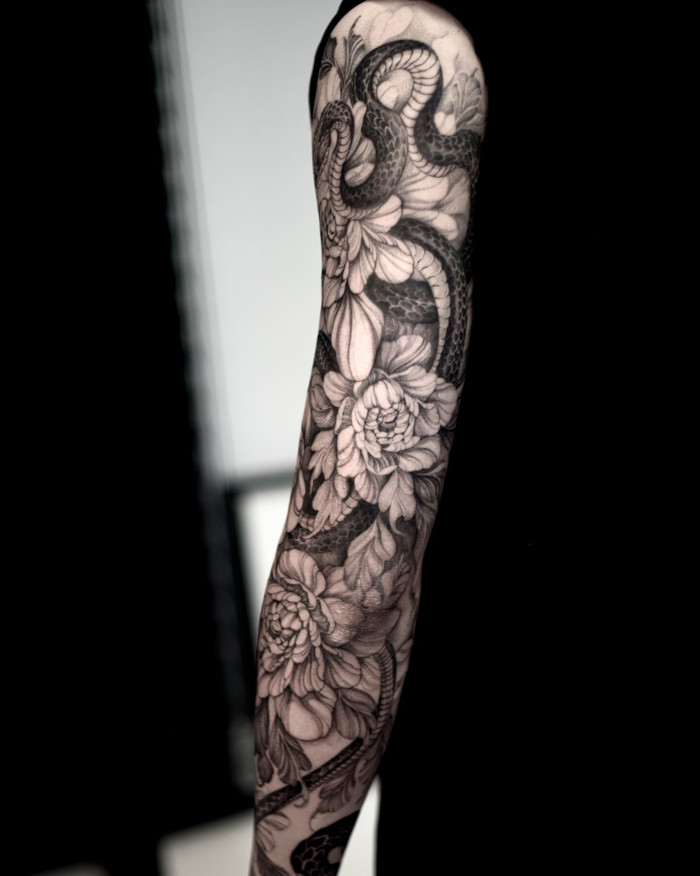 Snake and flowers realism tattoo on the forearm by Yongjun