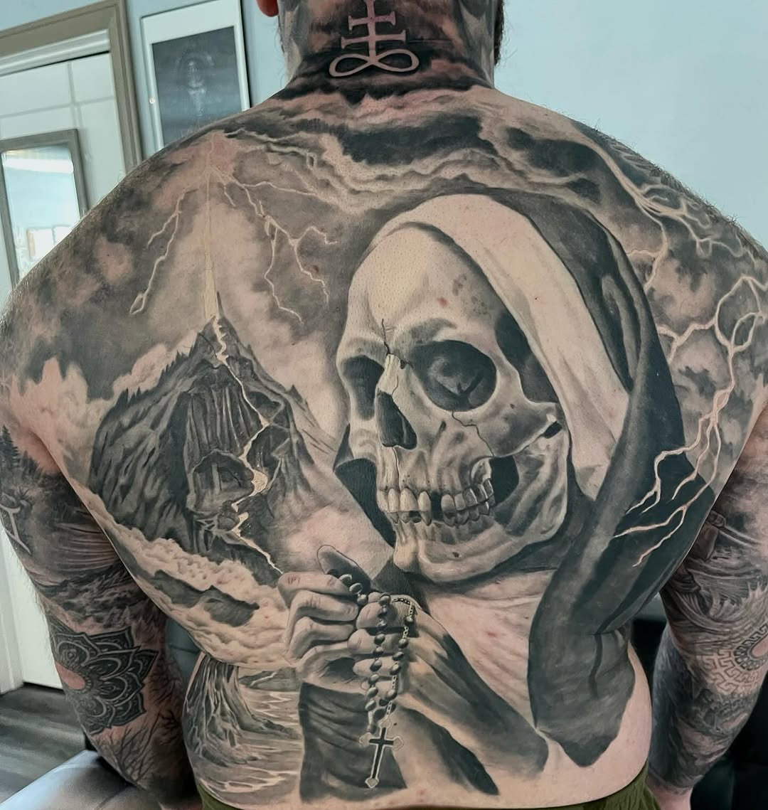 Skull with rosary and mountain landscape realism tattoo on the back by Antonio Massimino
