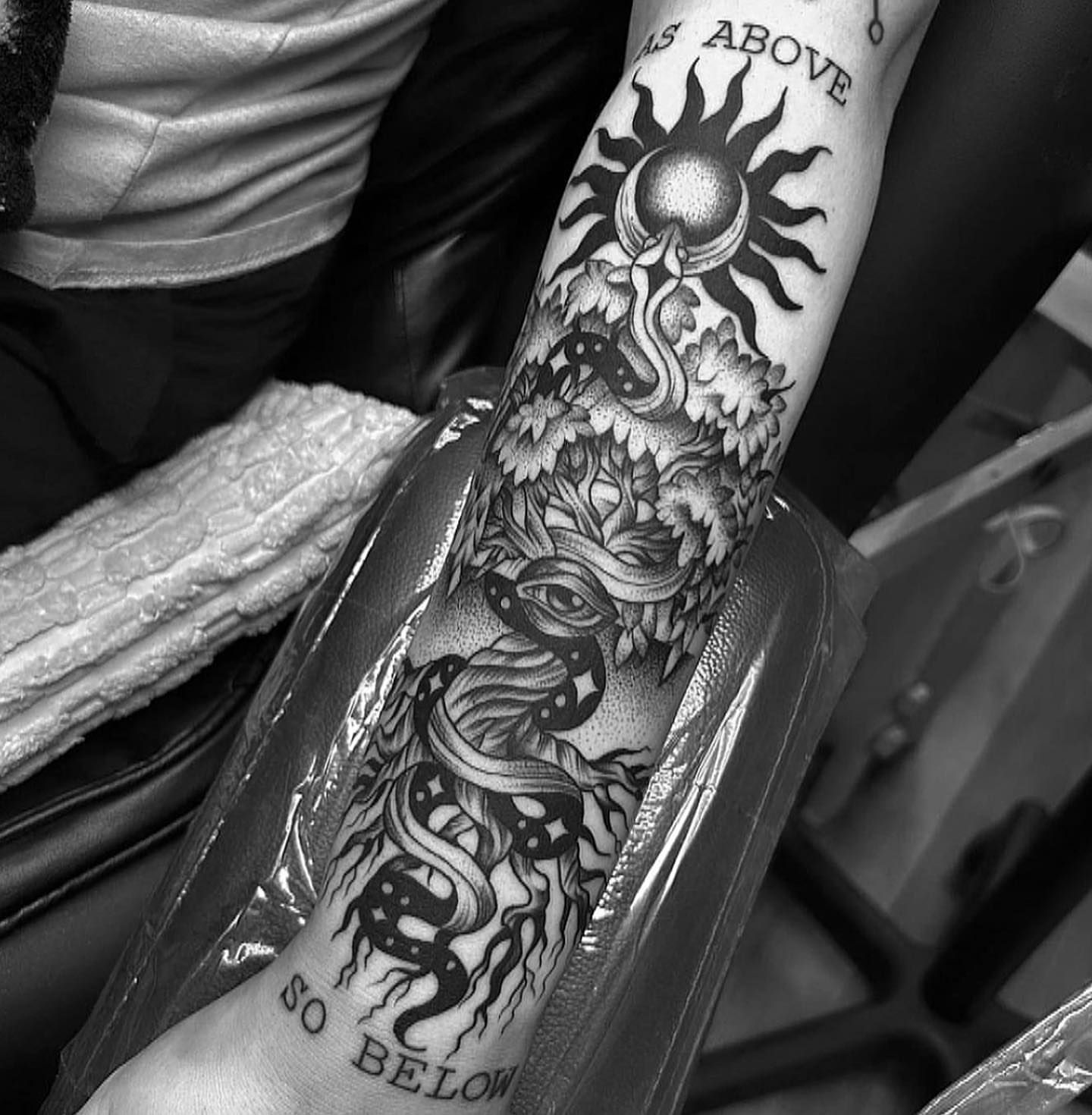 Serpent and sun dotwork tattoo on the forearm by Anna Nicole Thomas