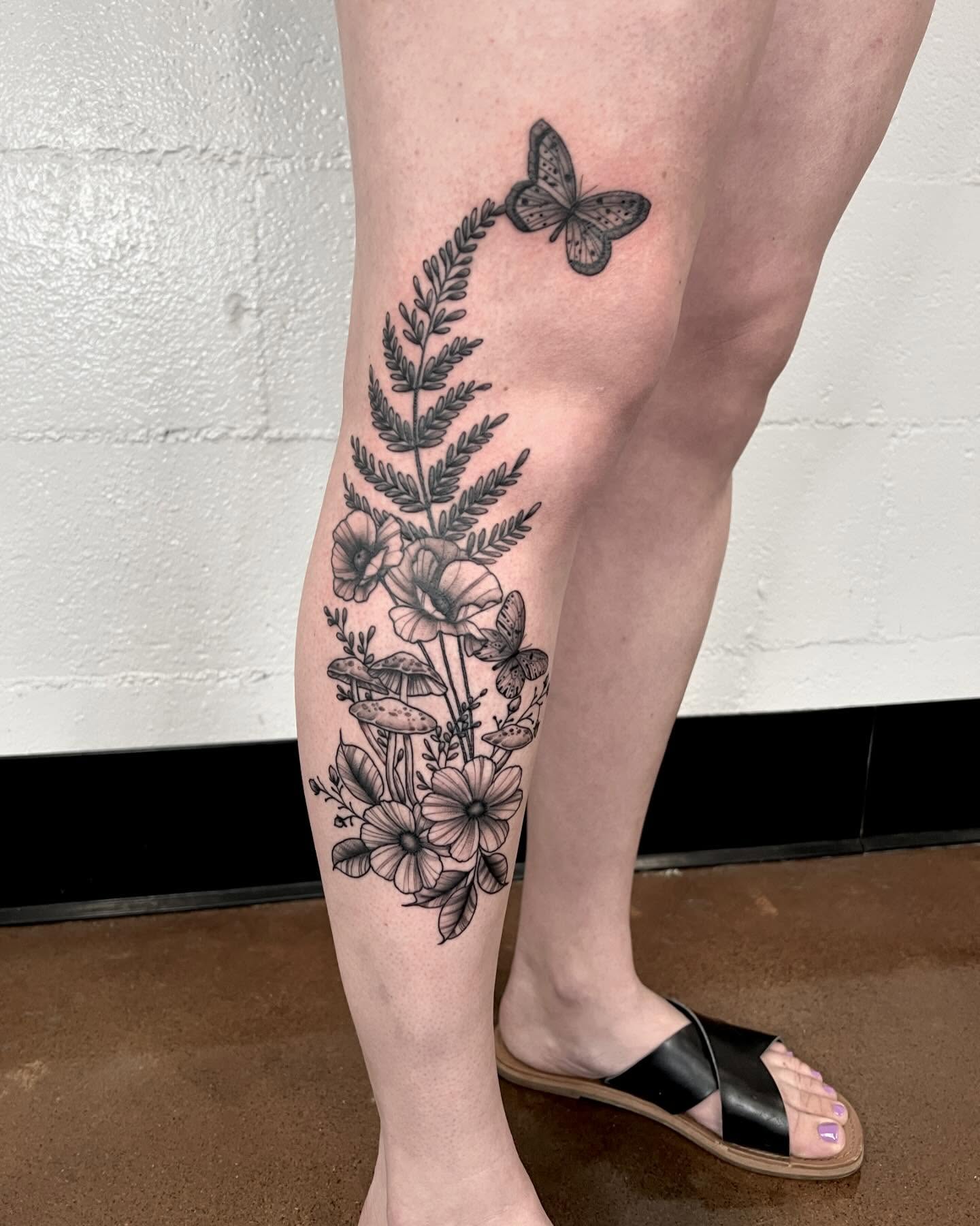 Floral arrangement with butterfly black and grey tattoo on the calf by Drew Foster, Toledo, Ohio