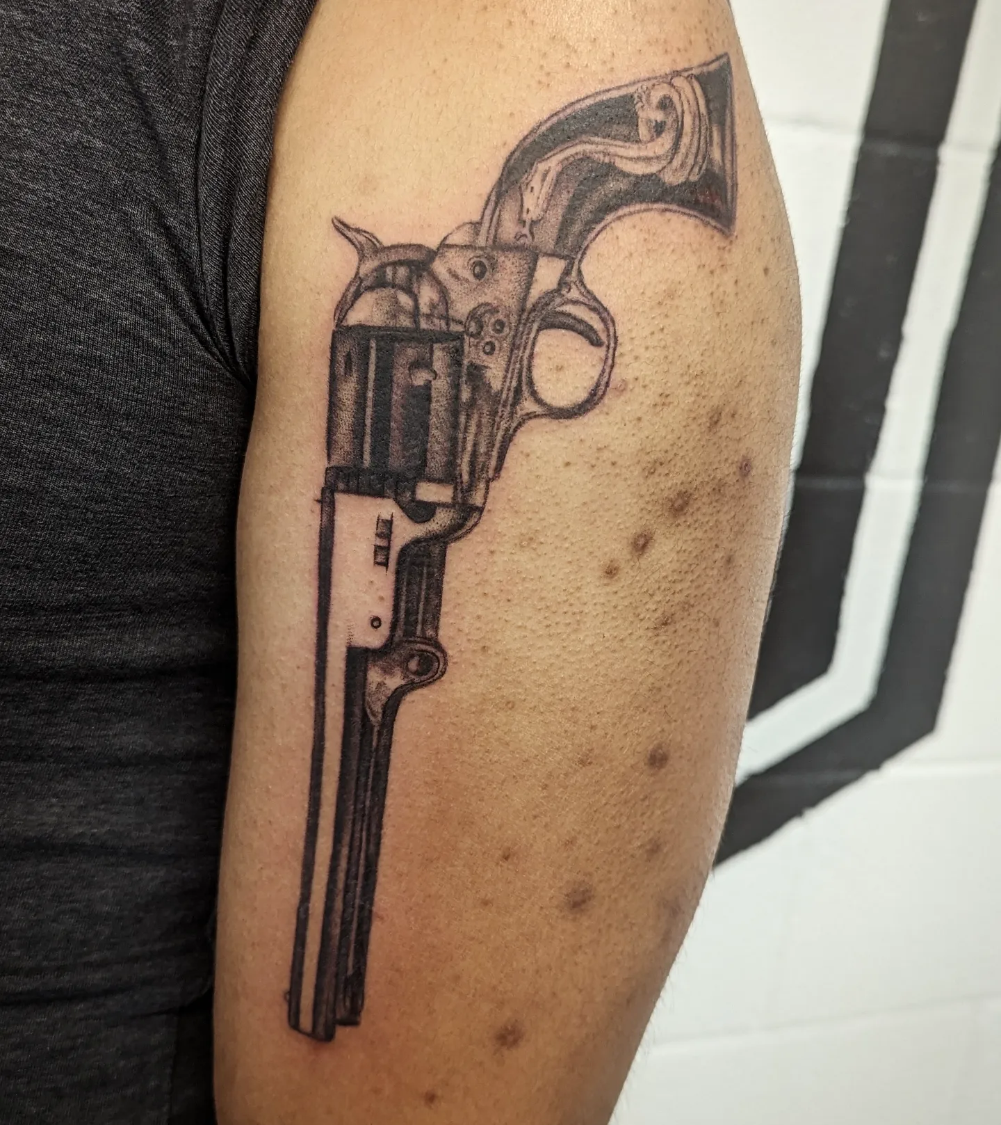 Revolver black and grey tattoo on the forearm by Krista Mc