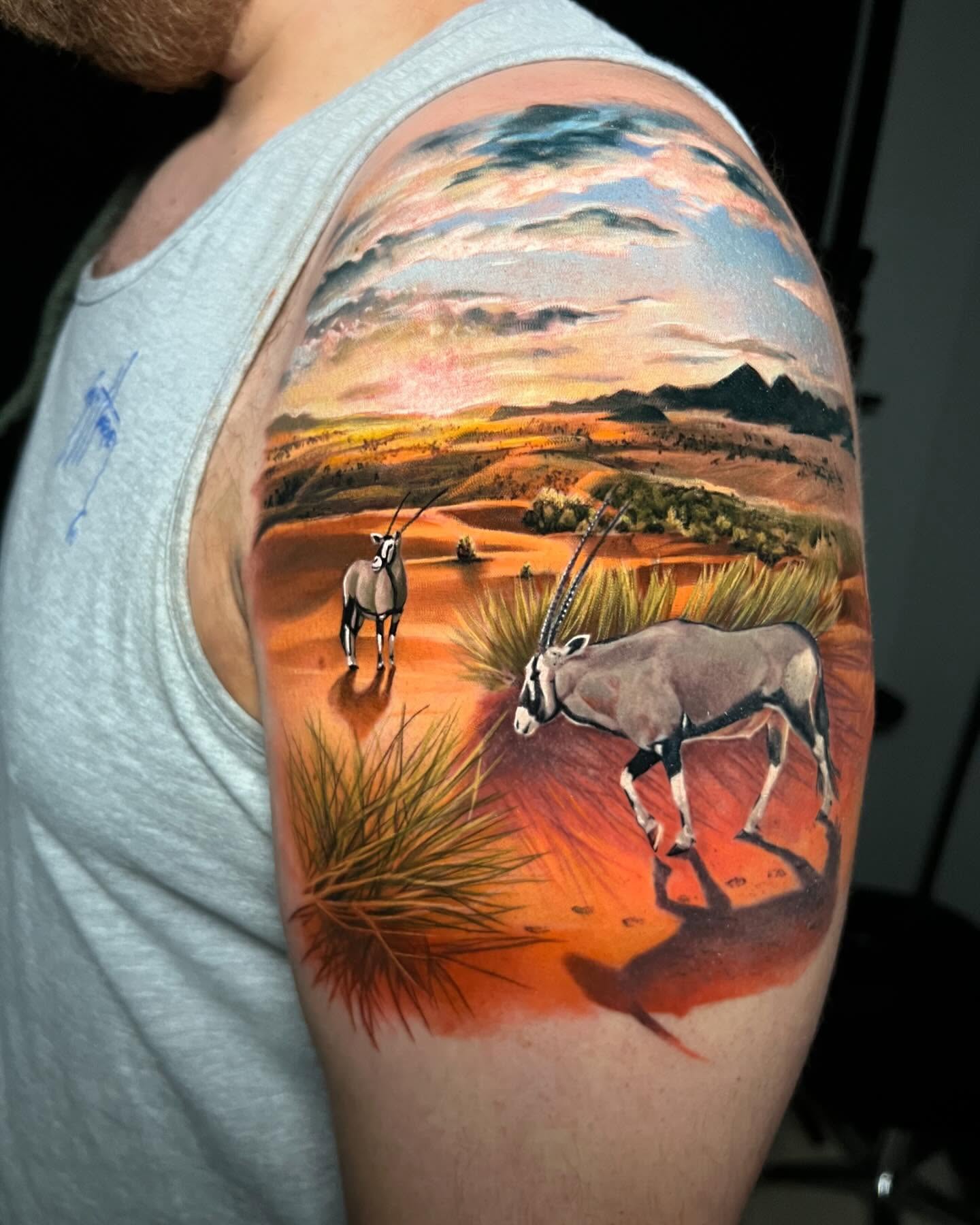 Desert landscape with antelope realism tattoo on the shoulder by Derek Gardner