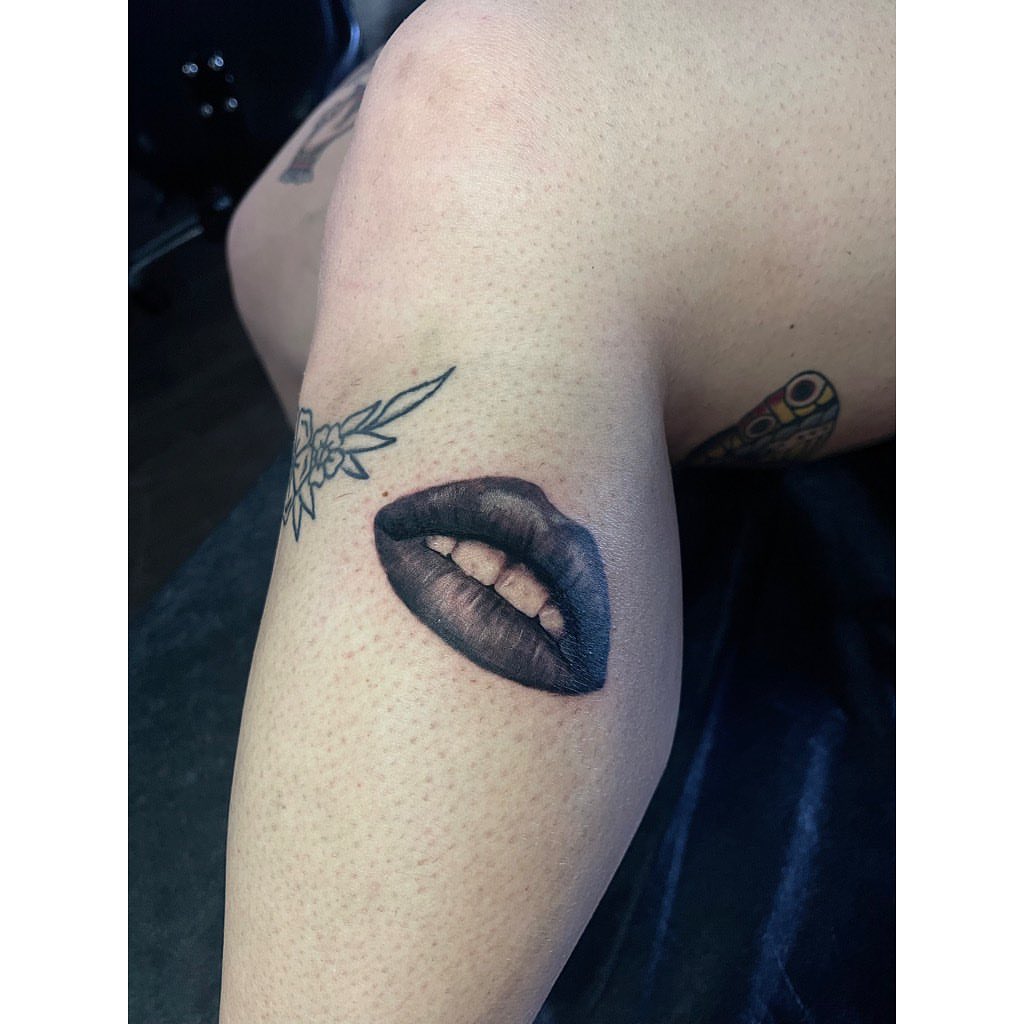 Lips black and grey tattoo on the forearm by Jelly