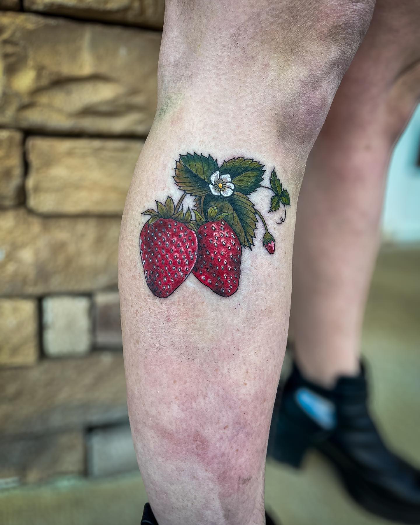 Strawberries realism tattoo on the thigh by Reagan Sutton
