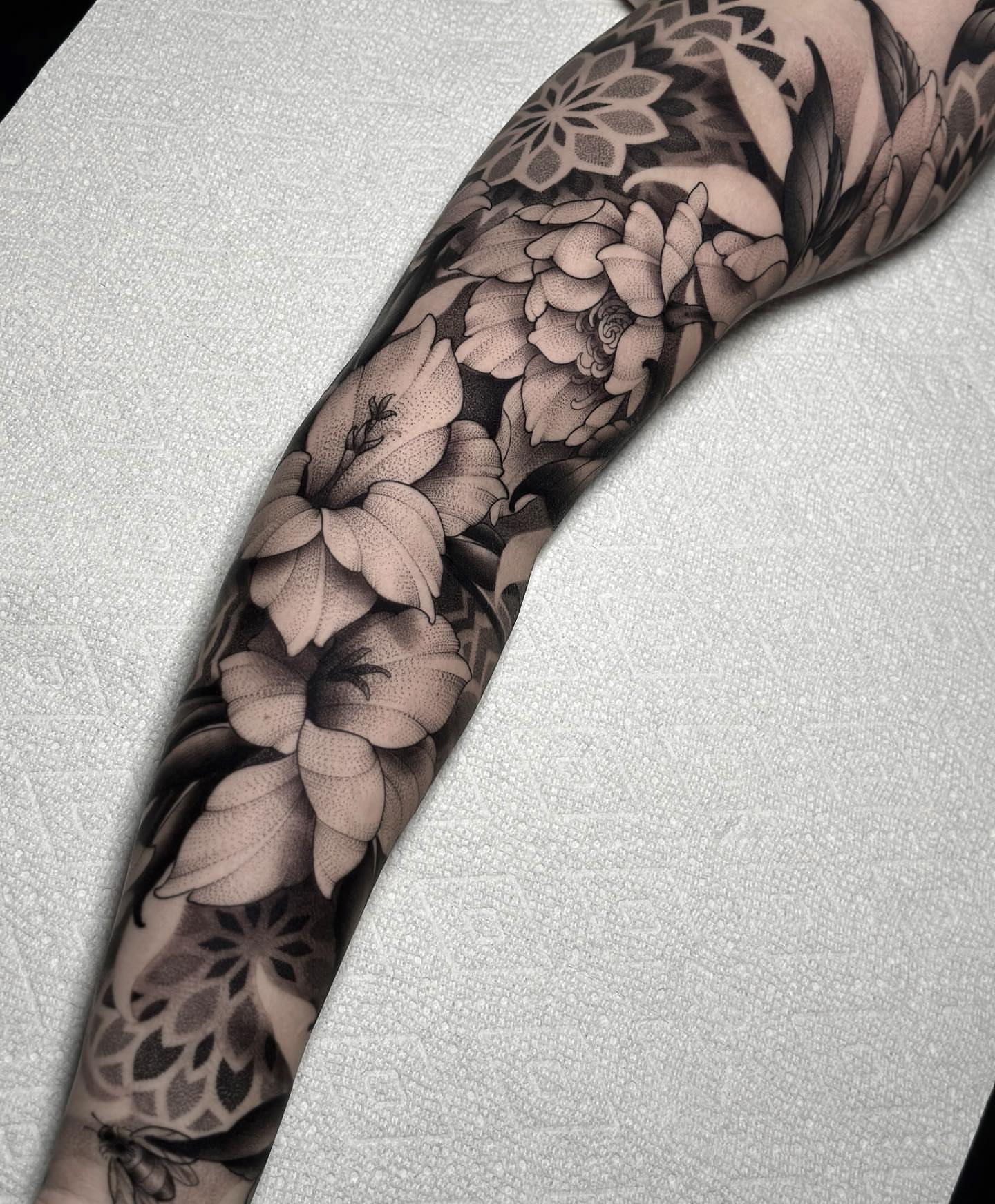 Floral sleeve black and grey tattoo on the forearm by San Diego
