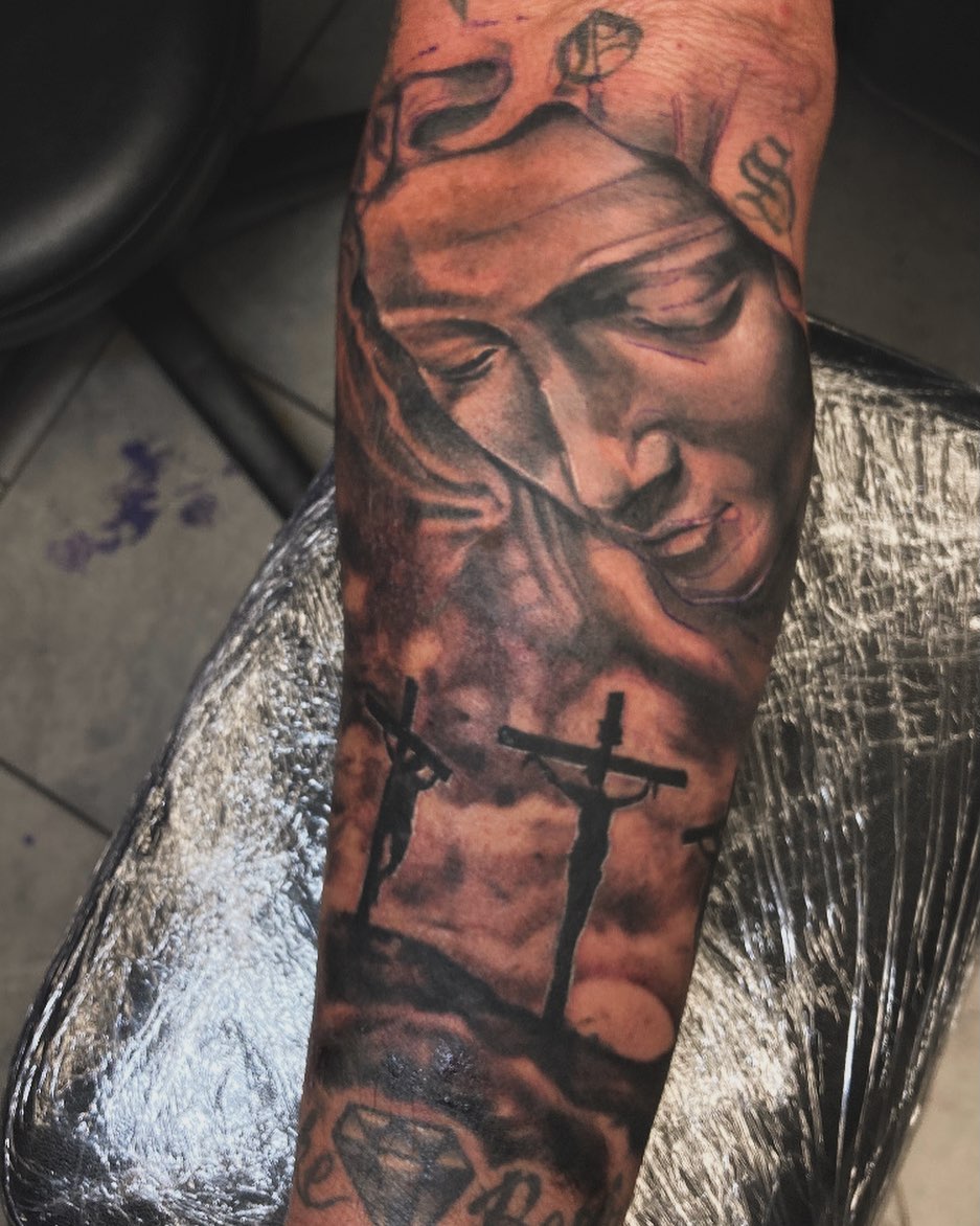 Religious figure realism tattoo on the forearm by Markeith “Black Jesus” Heard
