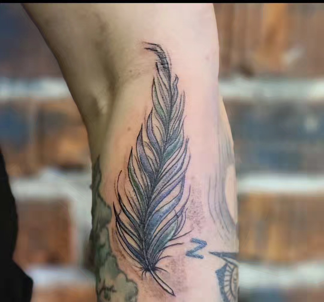 Feather black and grey tattoo on the forearm by Tim Andrews