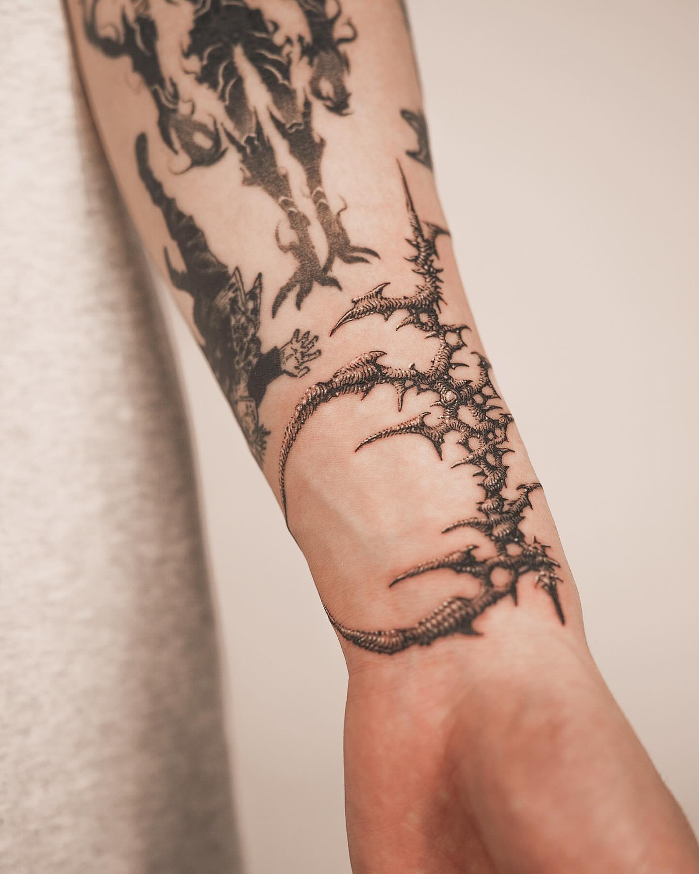 Thorns and dragon geometric tattoo on the forearm by Yujhi