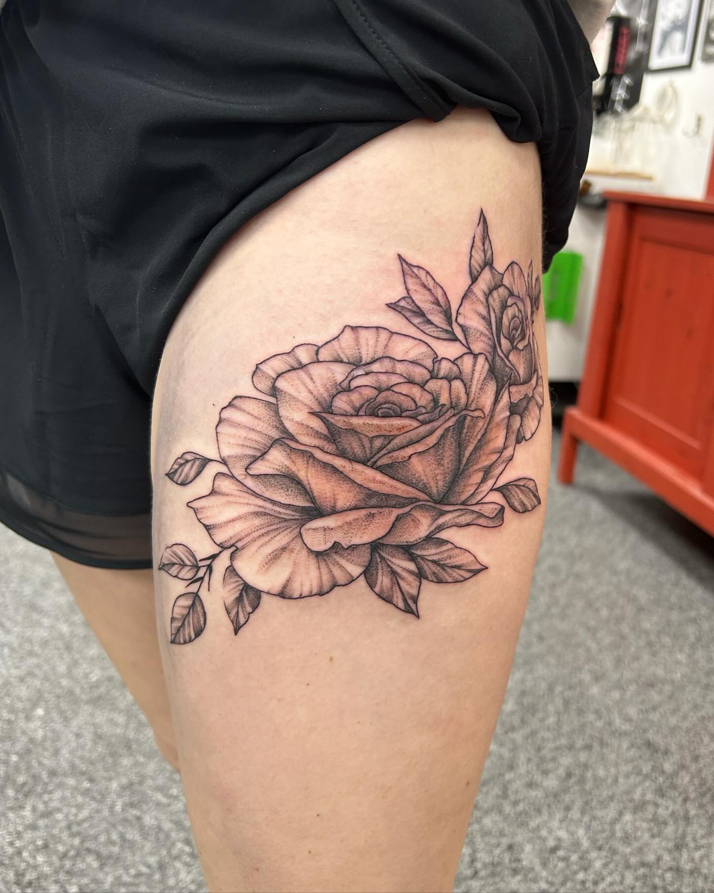 Rose black and grey tattoo on the thigh by Jayda Shell