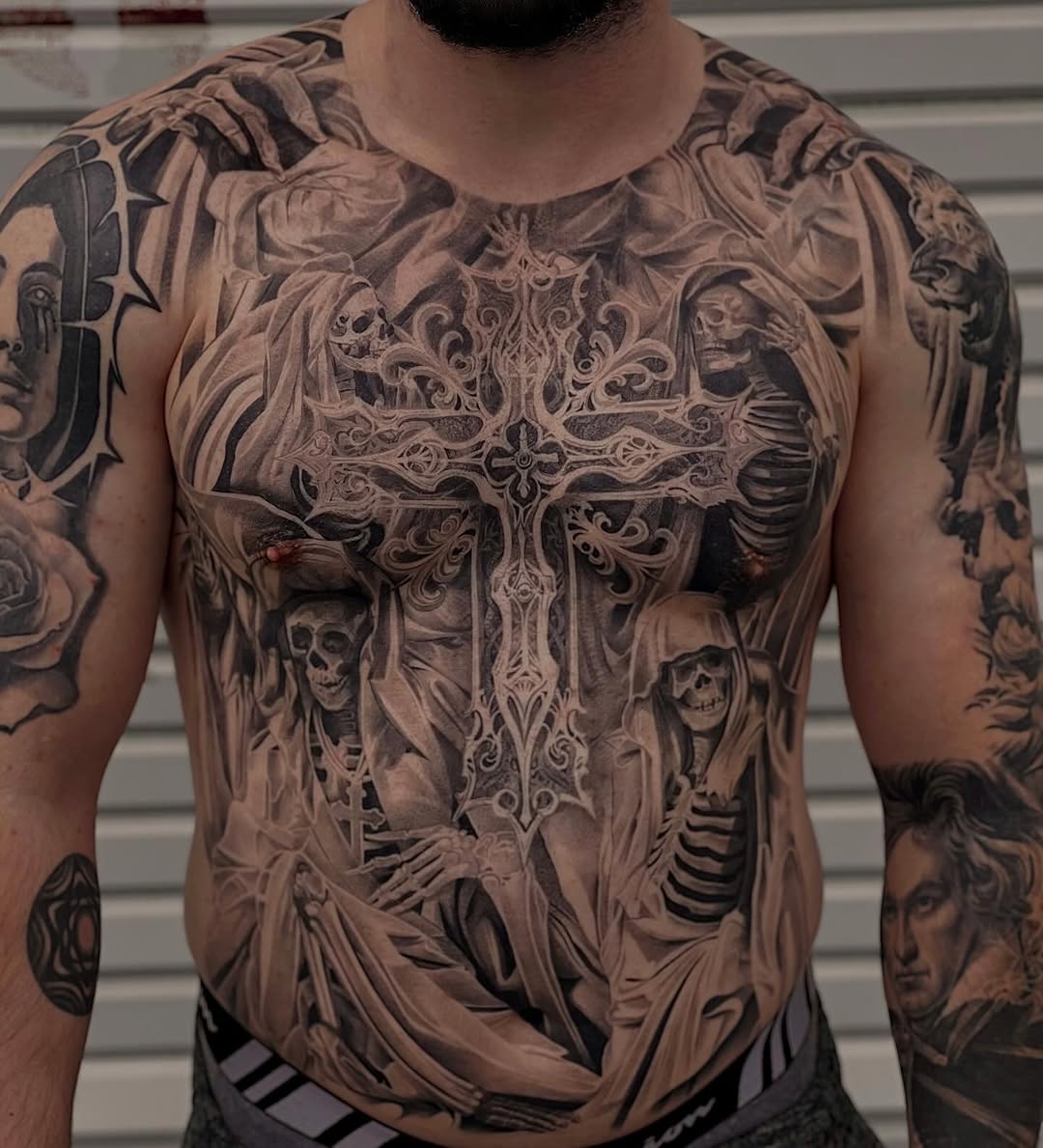 Cross with skeletons and drapery realism tattoo on the torso by sacramento tattoo CA