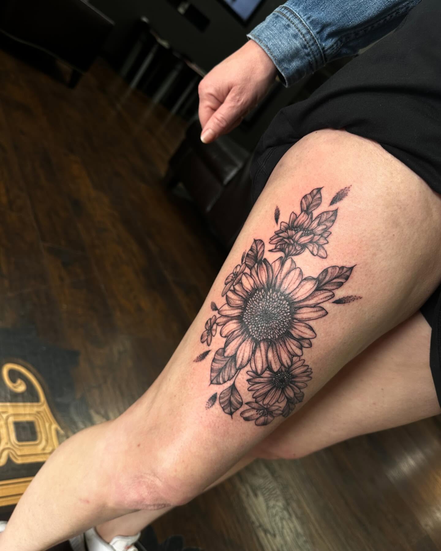 Sunflowers black and grey tattoo on the thigh by Kassie Perian