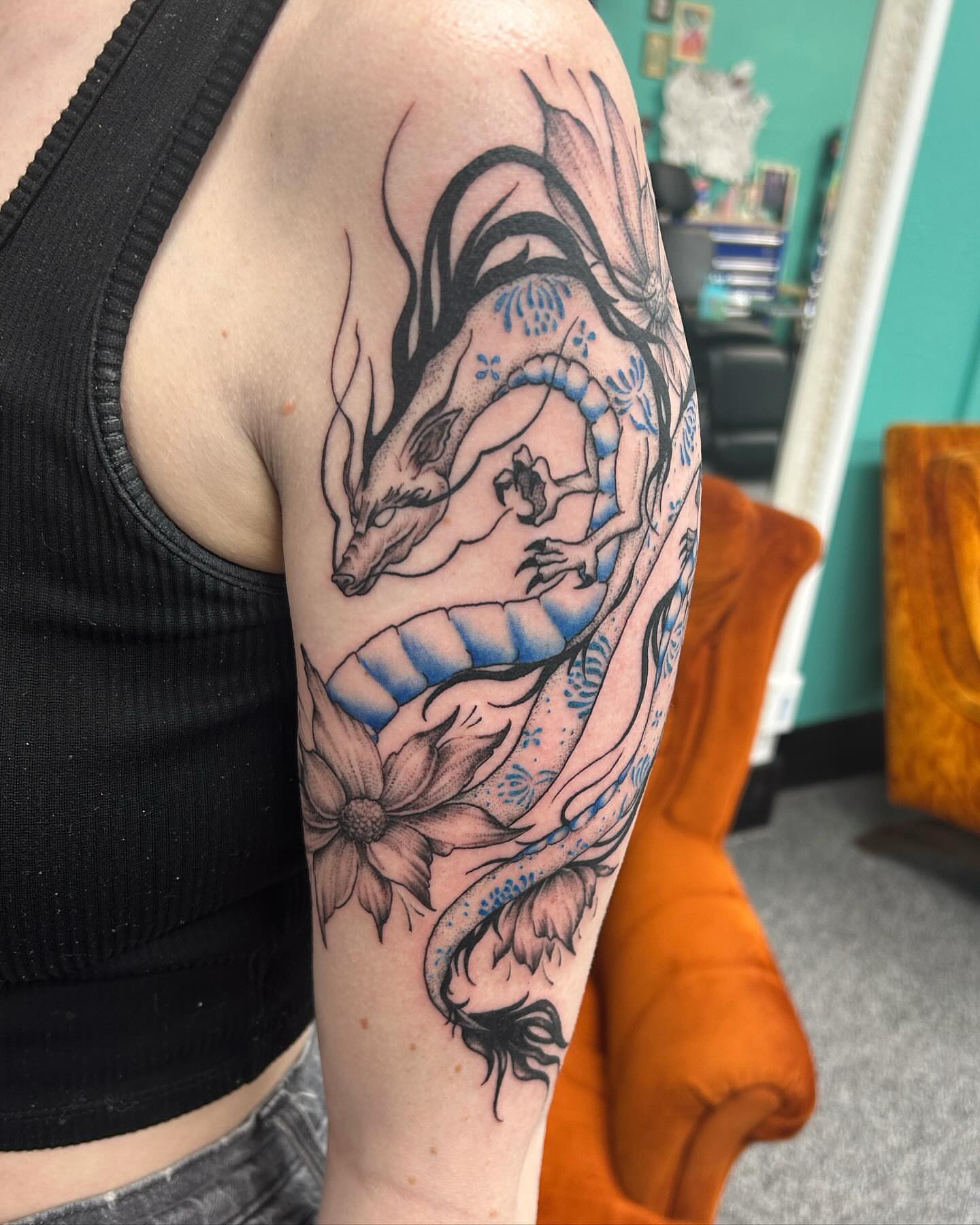 Dragon and flower dotwork tattoo on the forearm by Jayda Shell