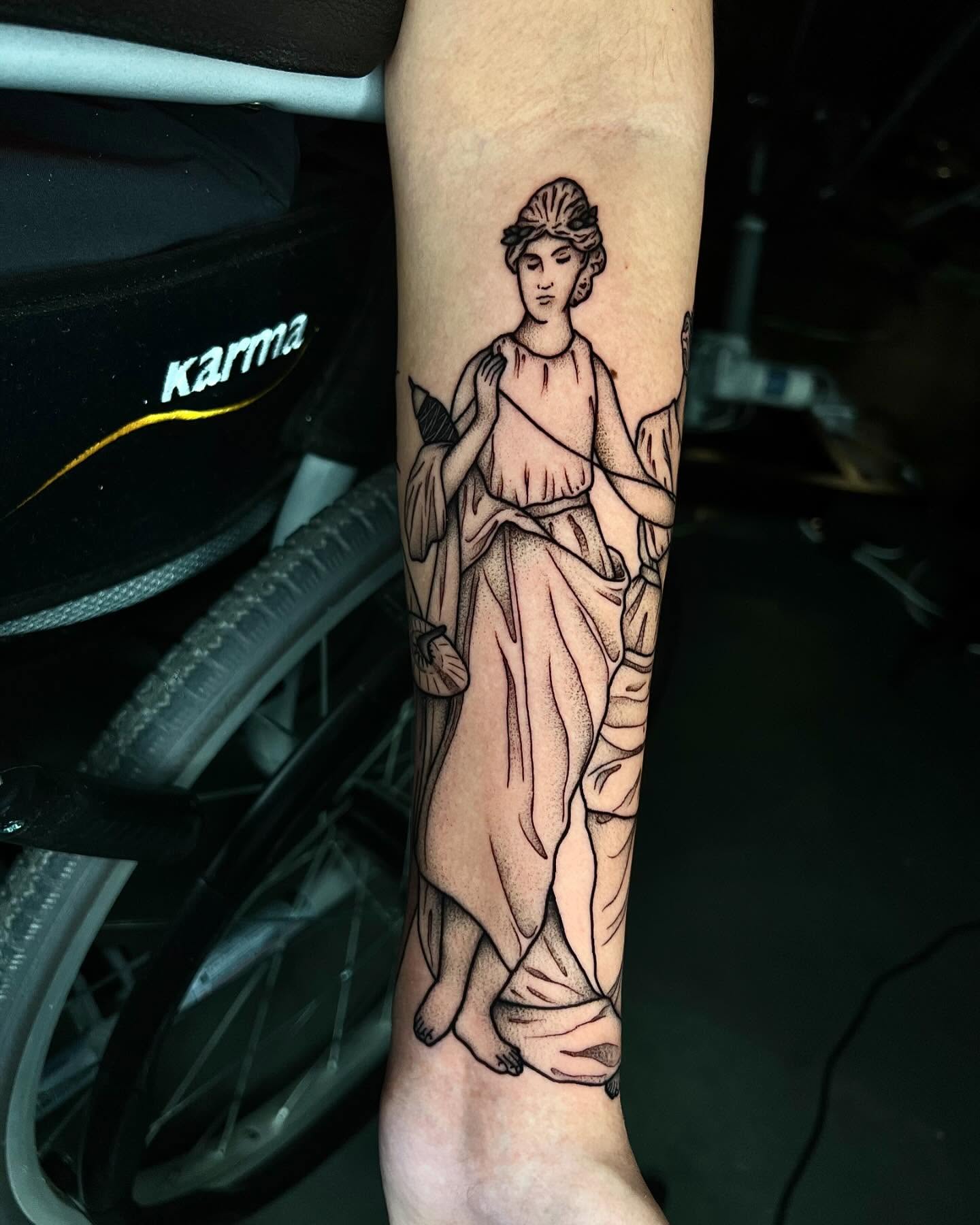 Statue black and grey tattoo on the forearm by Pam Sanders