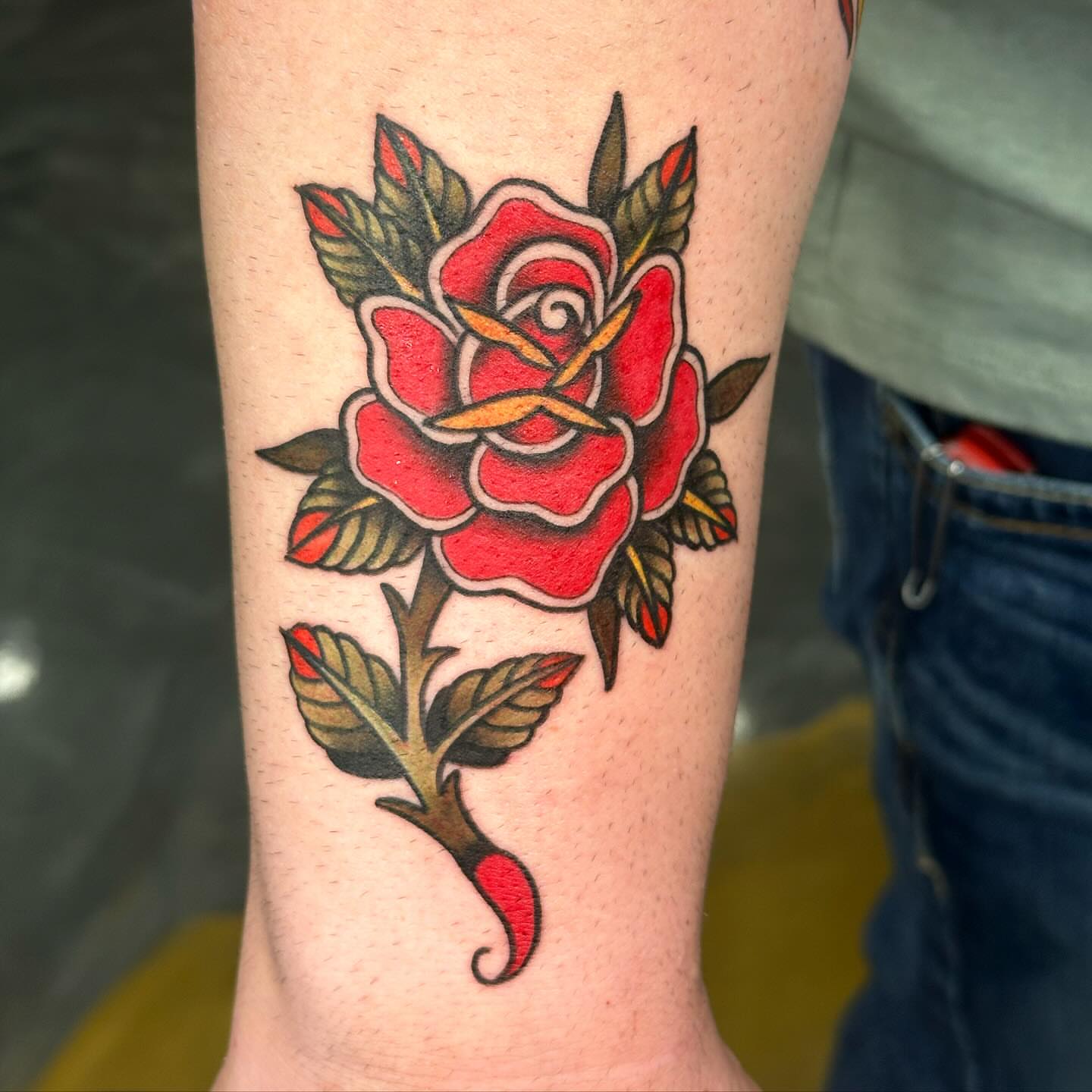 Red rose American traditional tattoo on the forearm by Christopher Heffley