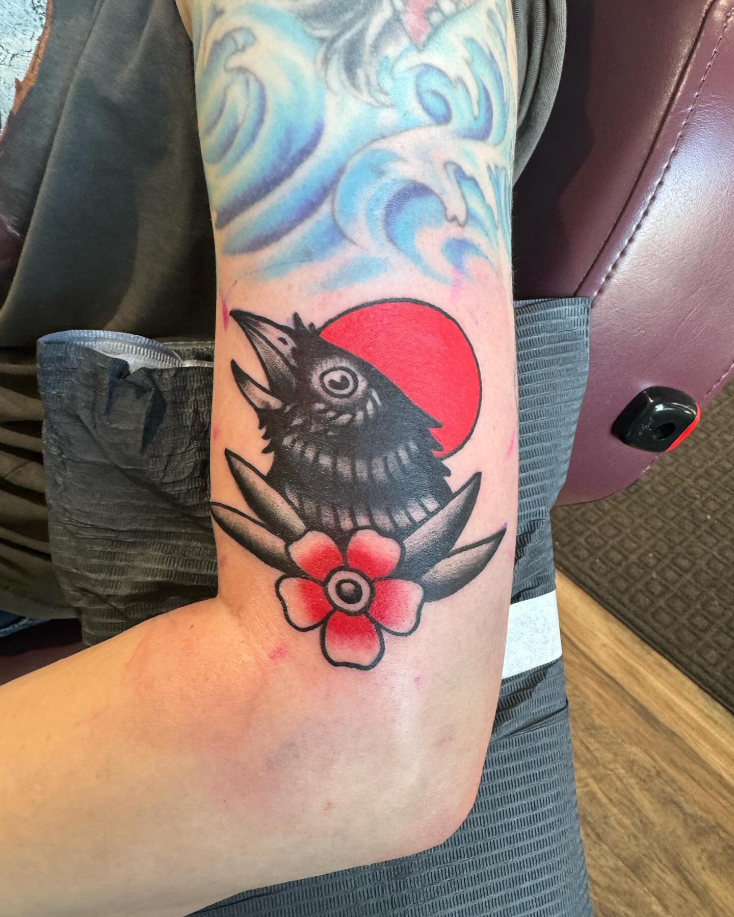 Crow and flower American traditional tattoo on the forearm by Minneapolis