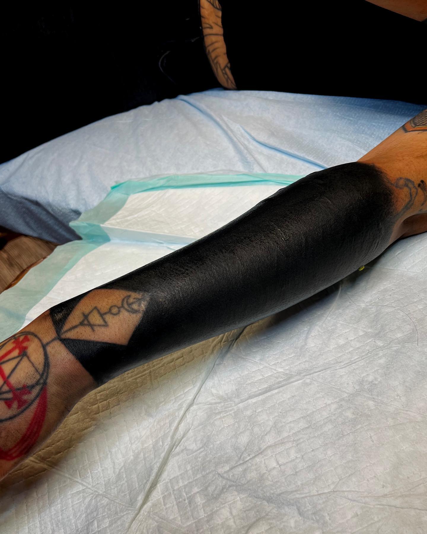 Black sleeve blackwork tattoo on the upper arm by Jon Crook, Portland, Oregon