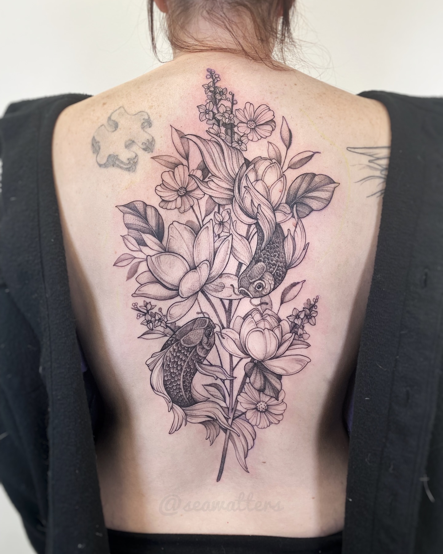 Flowers and fish black and grey tattoo on the back by Caitlin Watters