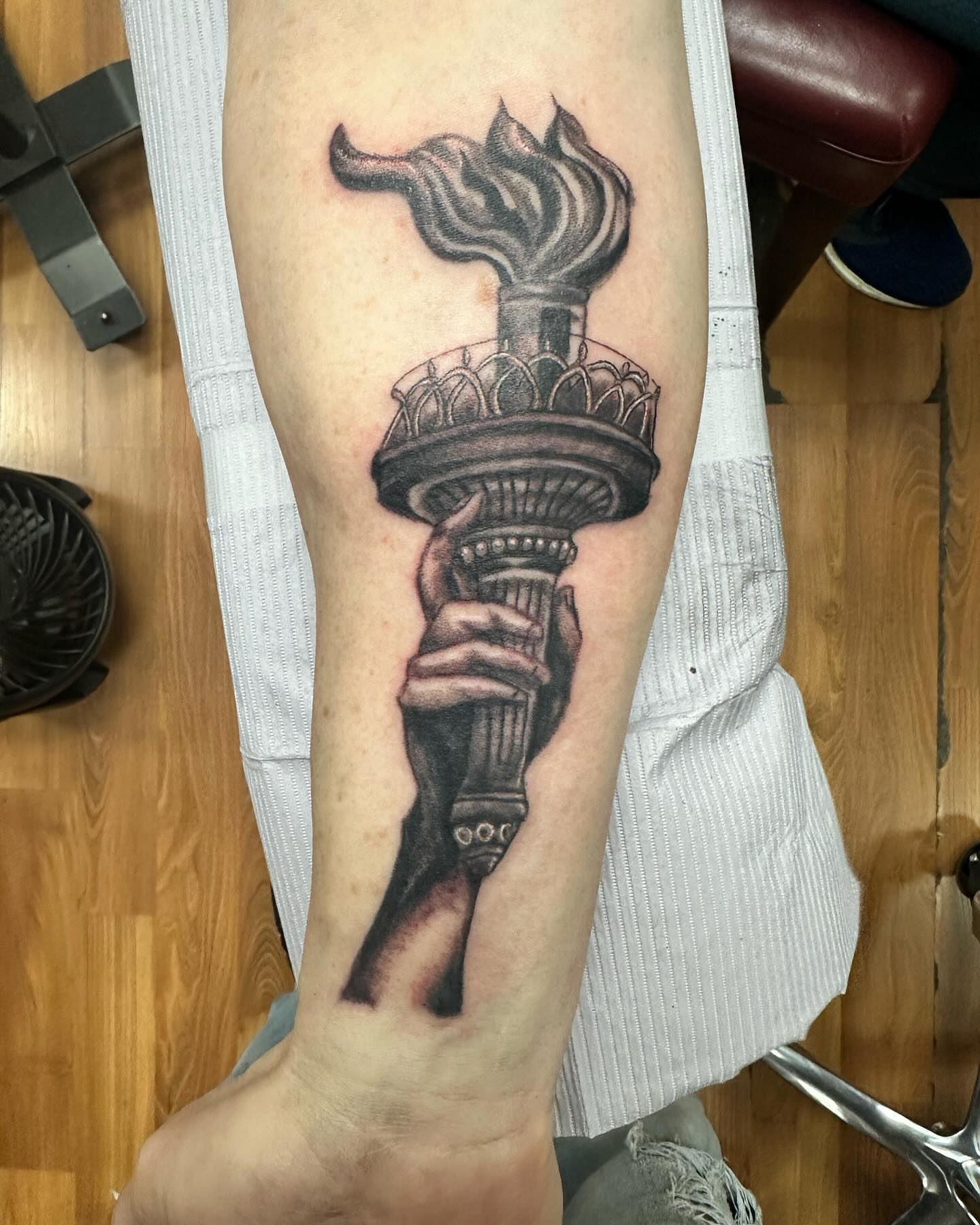 Statue of liberty torch black and grey tattoo on the forearm by KJ