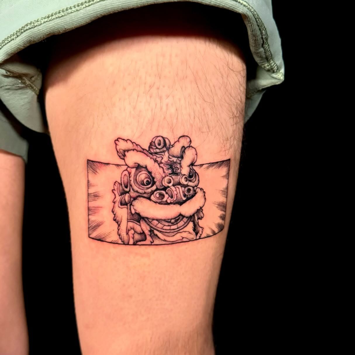 Lion dance mask black and grey tattoo on the thigh by Navei