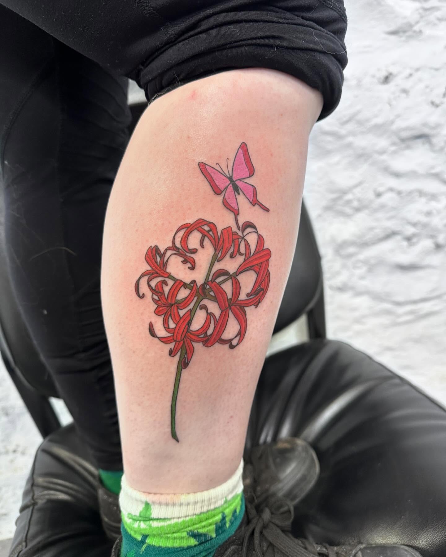 Red spider lily and butterfly realism tattoo on the thigh by Blake Owens, Nashville, Tennessee