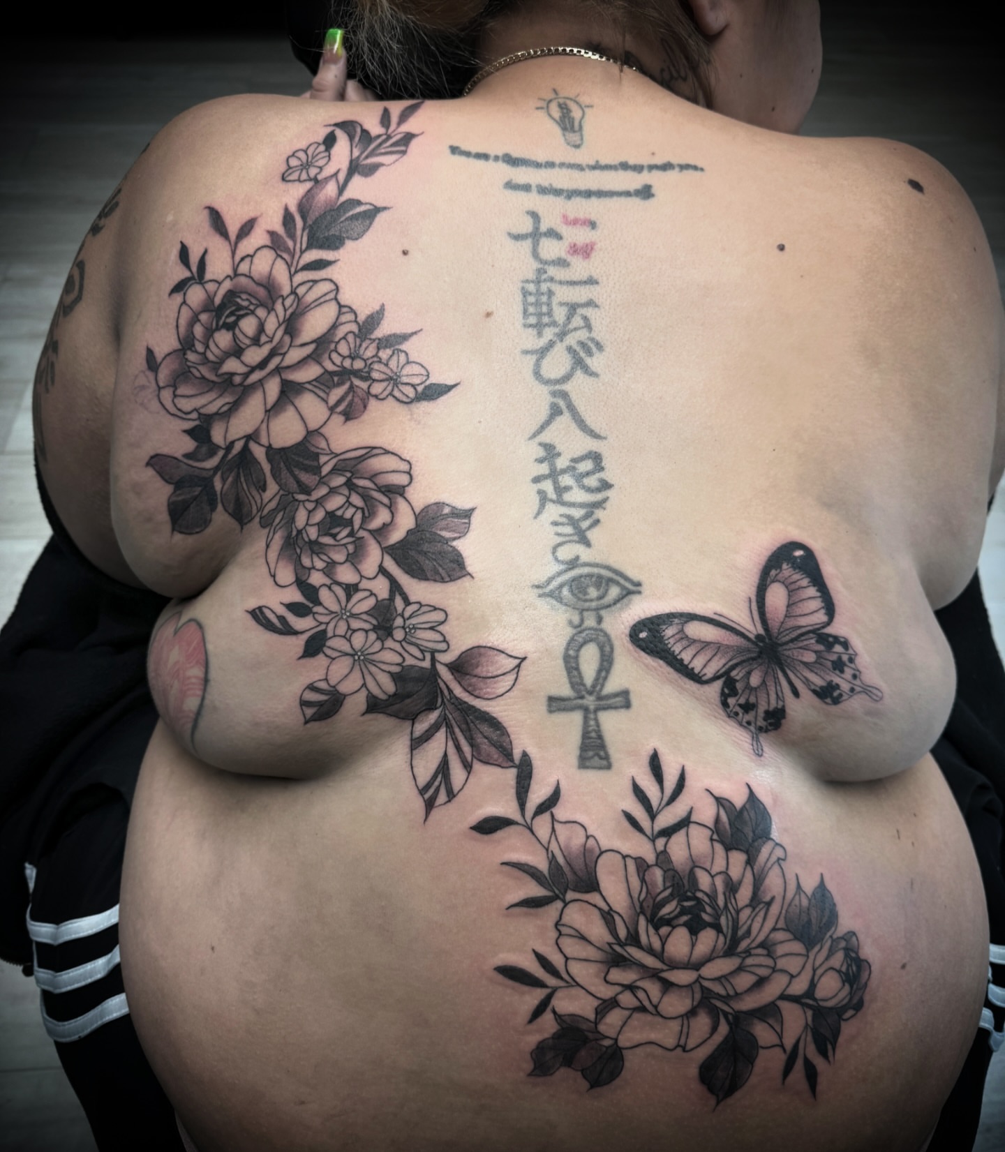 Floral arrangement black and grey tattoo on the back by Chip