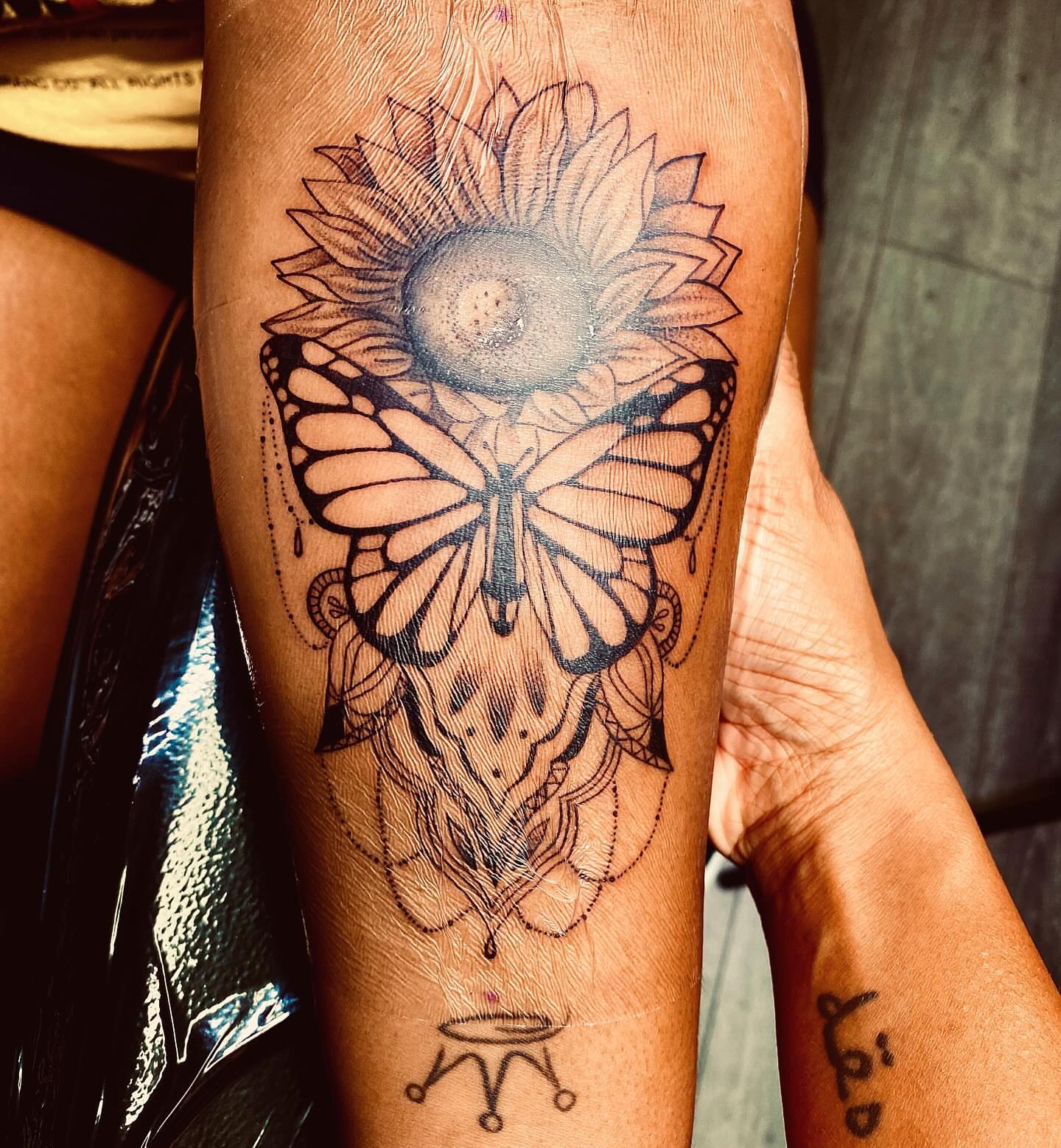 Sunflower and butterfly geometric tattoo on the forearm by Tiffany