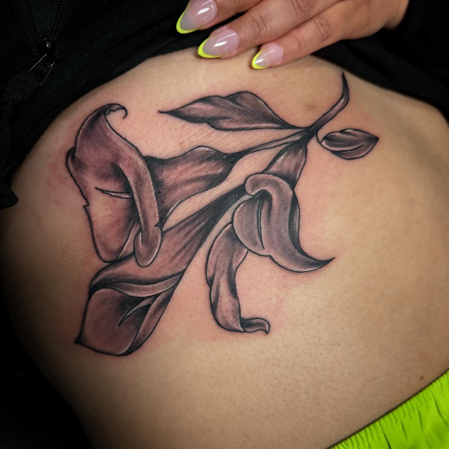 Lilies black and grey tattoo on the ribs by Anthony Pichardo 🦇