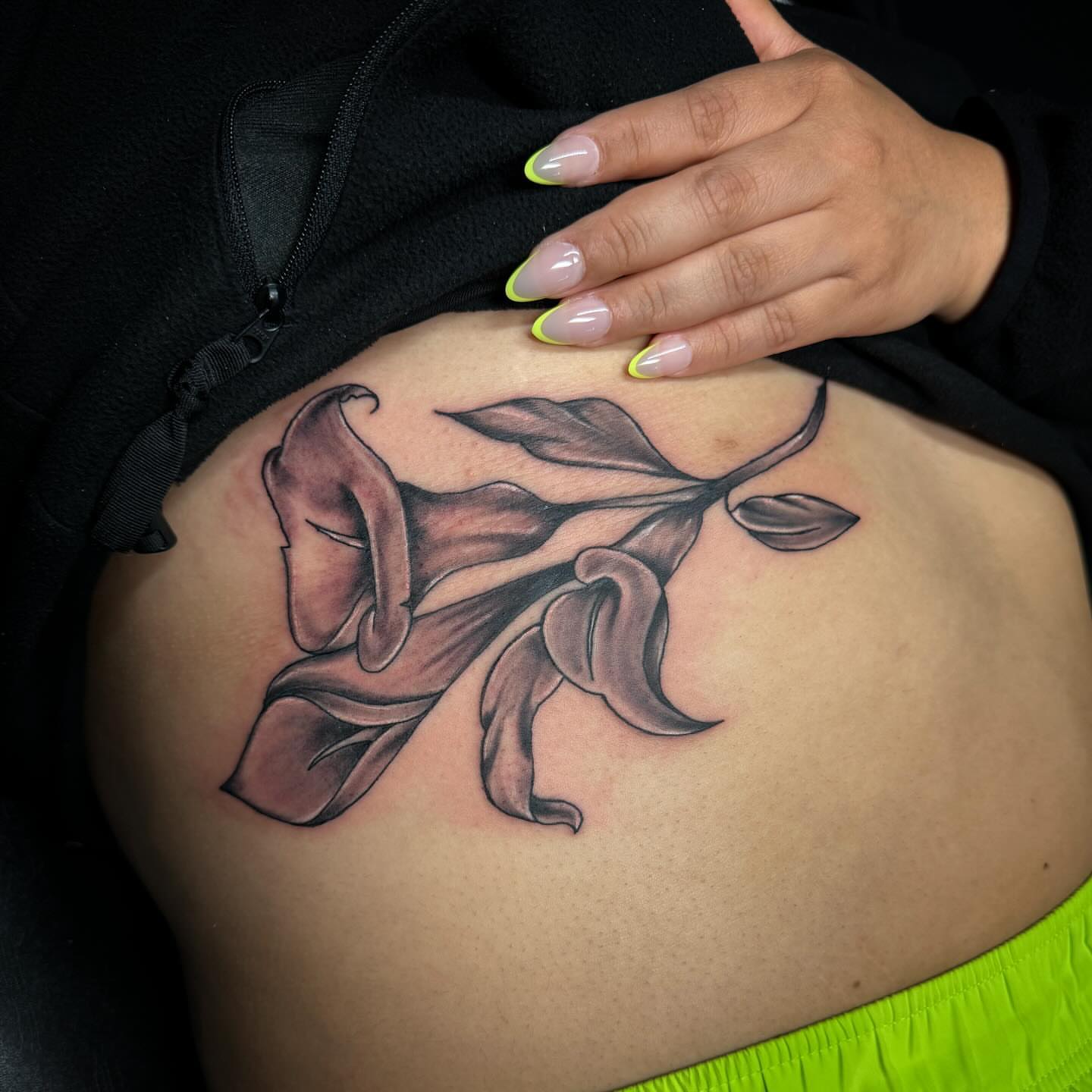 Lilies realism tattoo on the ribs by Anthony Pichardo 🦇