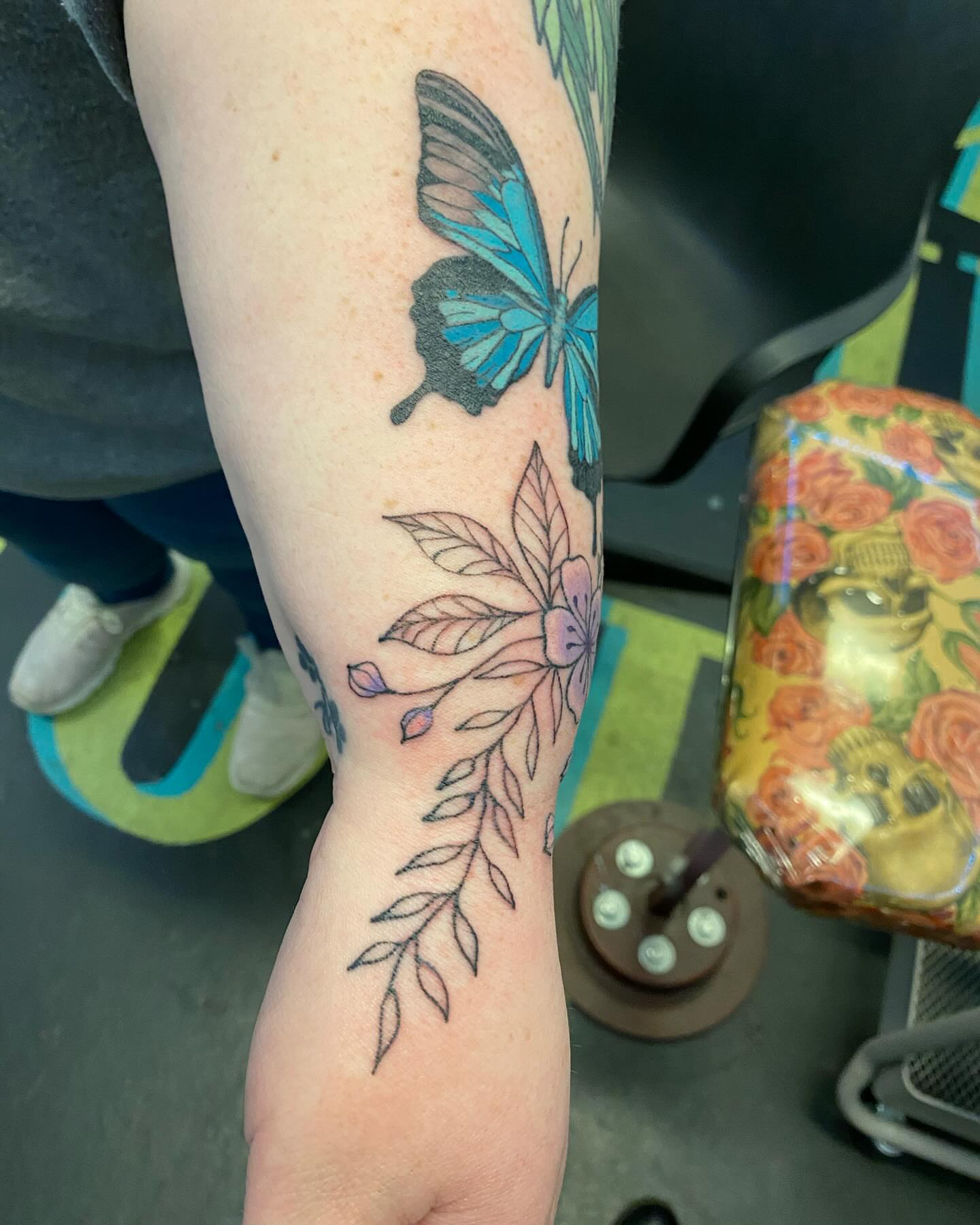 Butterfly and floral dotwork tattoo on the forearm by Tesla Kohl