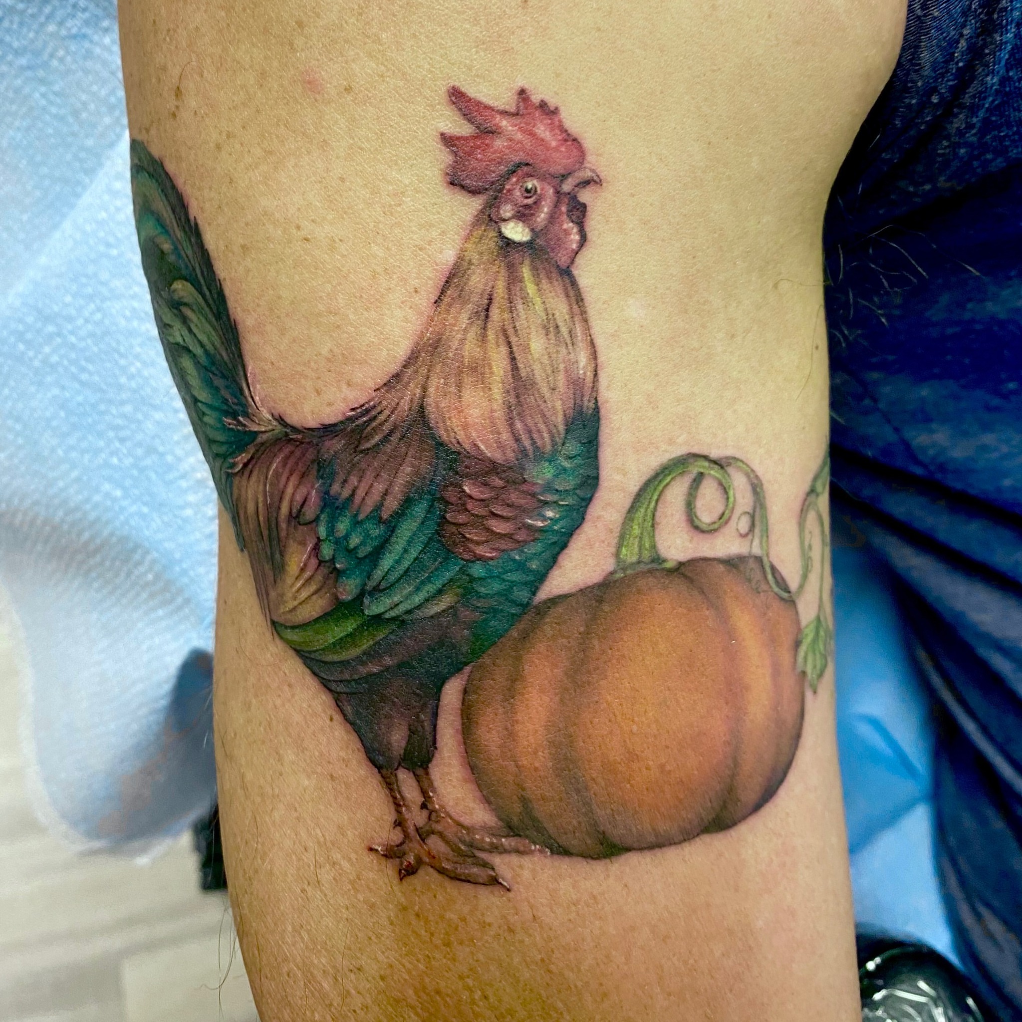 Rooster and pumpkin realism tattoo on the thigh by Emily Conner