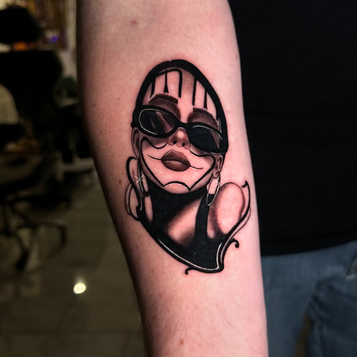 Woman wearing sunglasses black and grey tattoo on the forearm by Jorden Ruppe