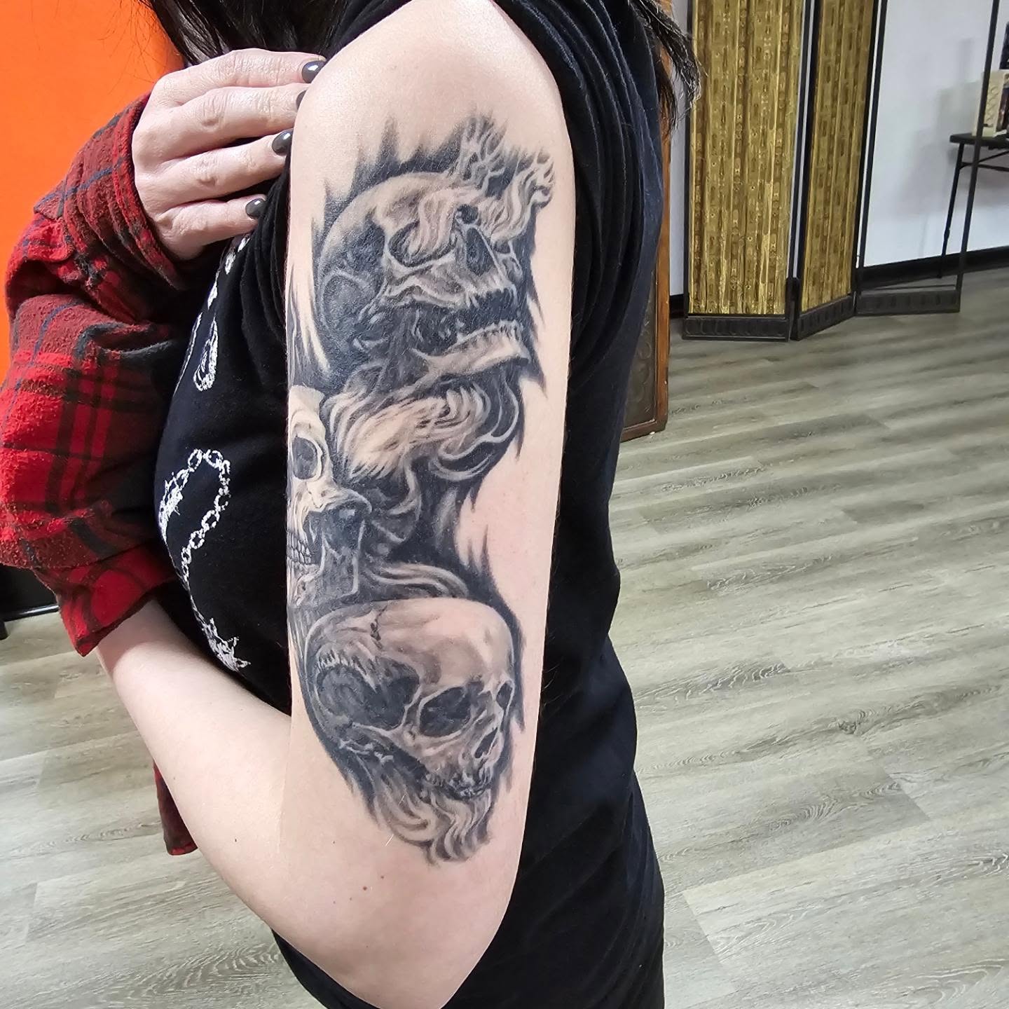 Skulls realism tattoo on the upper arm by Gene Britton